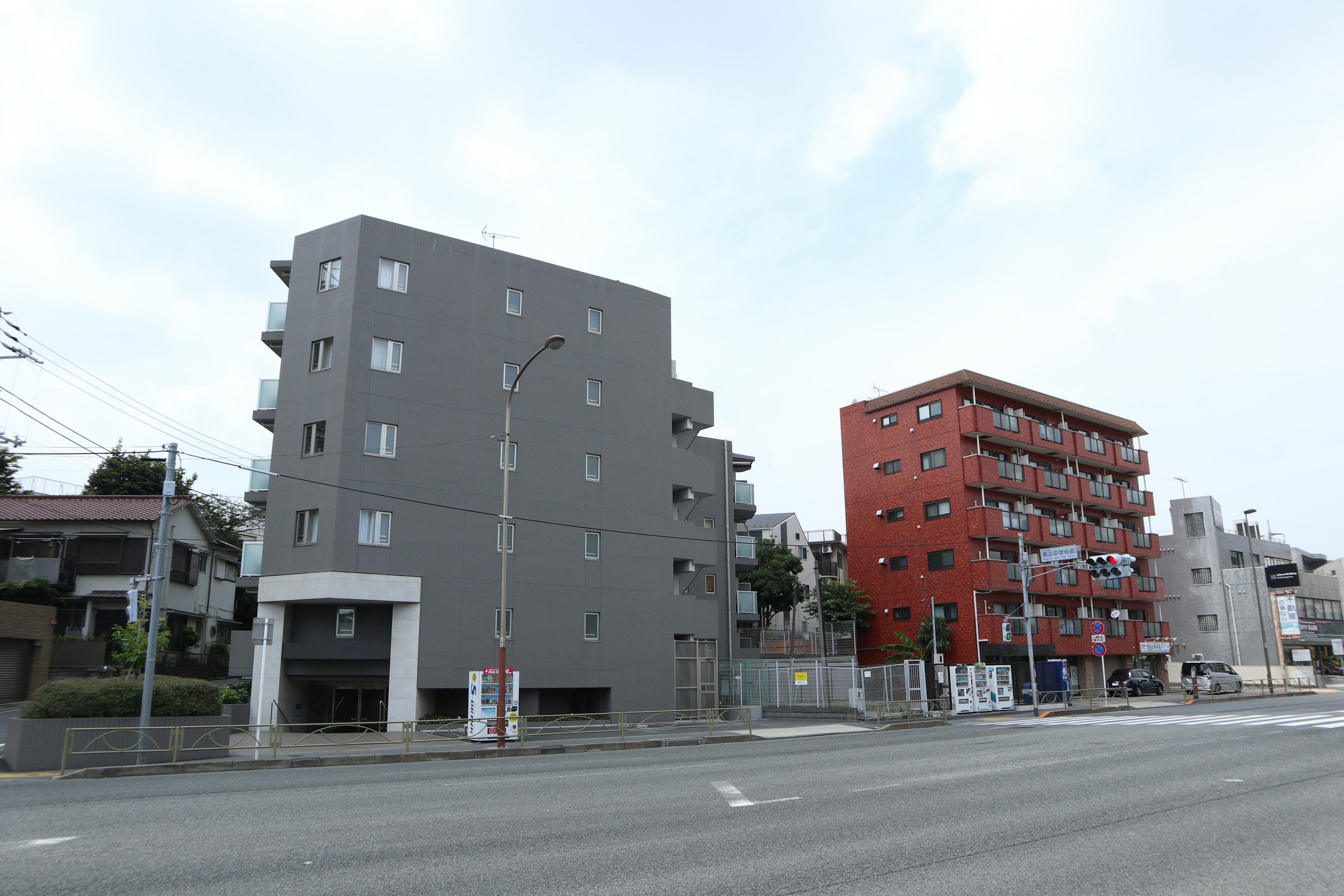 Street view featuring gray and red apartment buildings