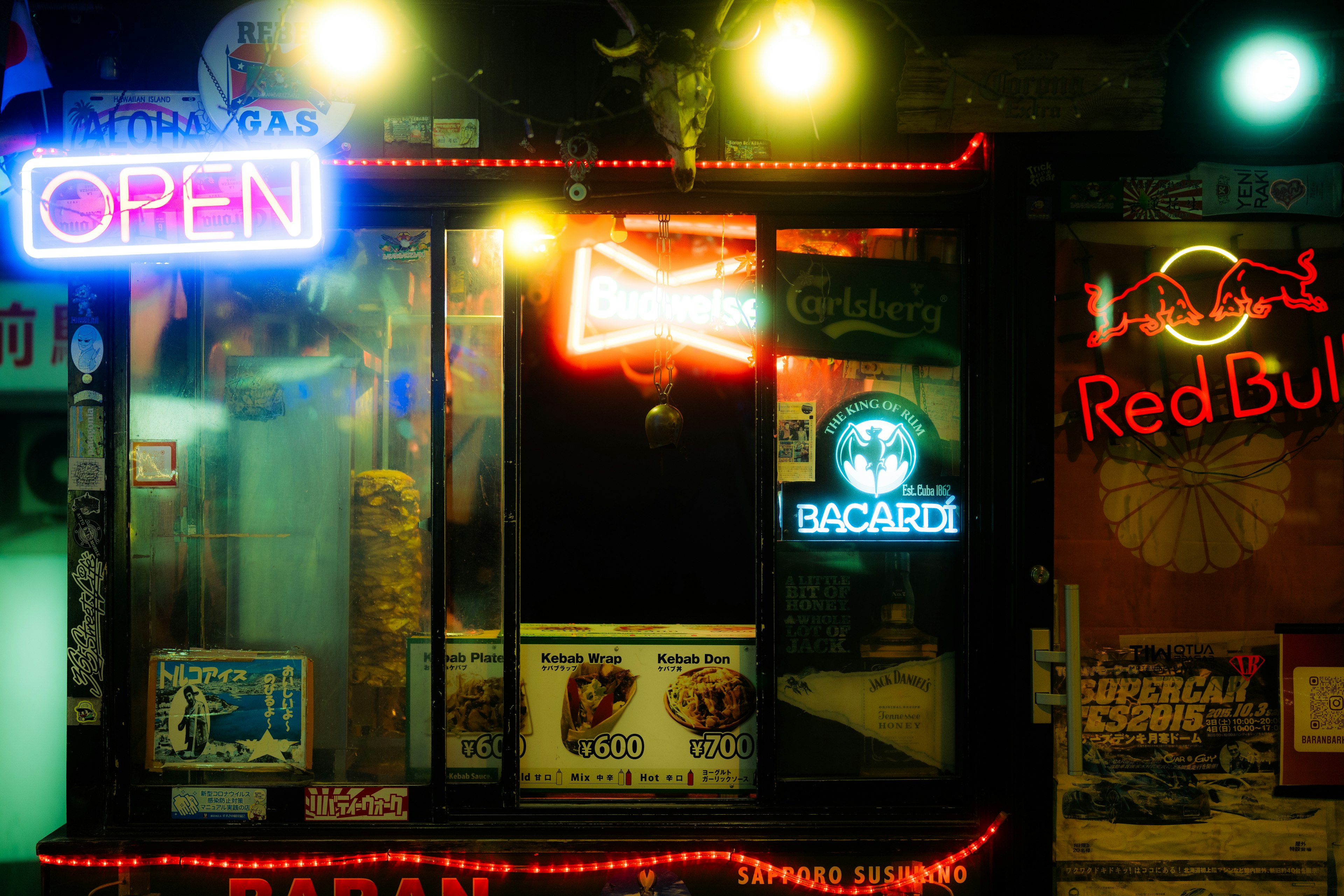 Insegne al neon che illuminano l'entrata di un bar creando un'atmosfera notturna vivace