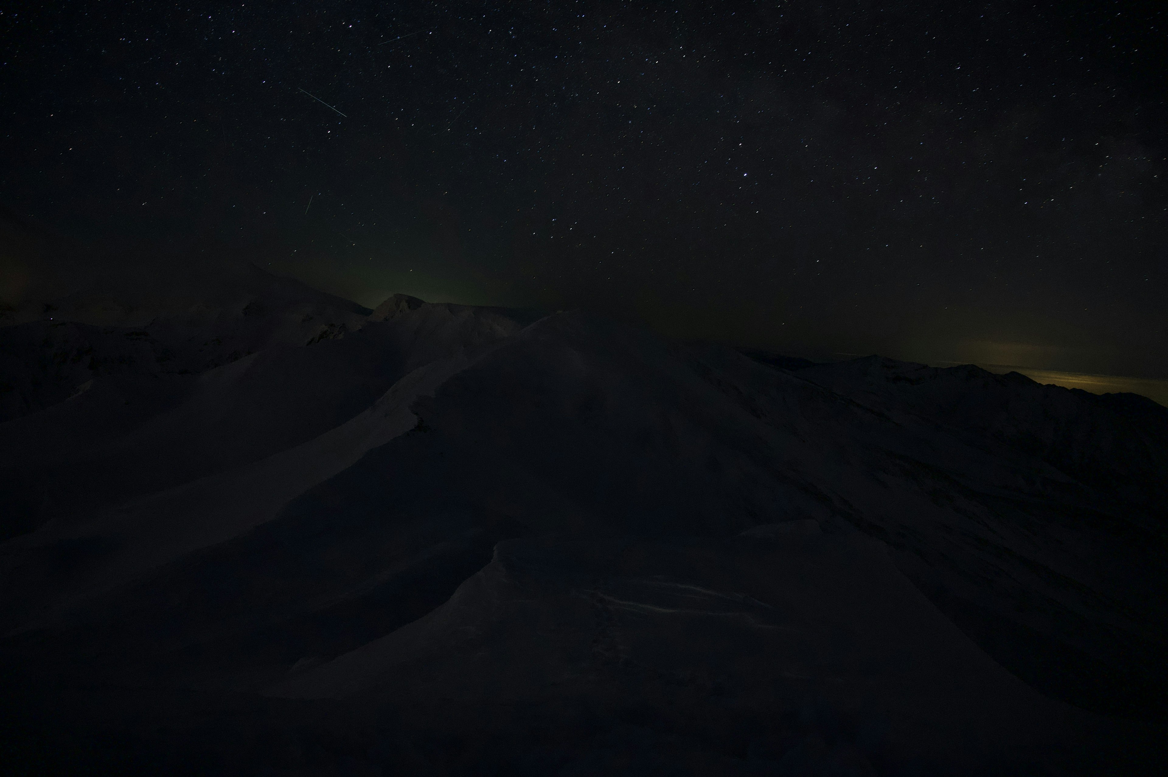 Paesaggio notturno con cielo stellato sopra le montagne