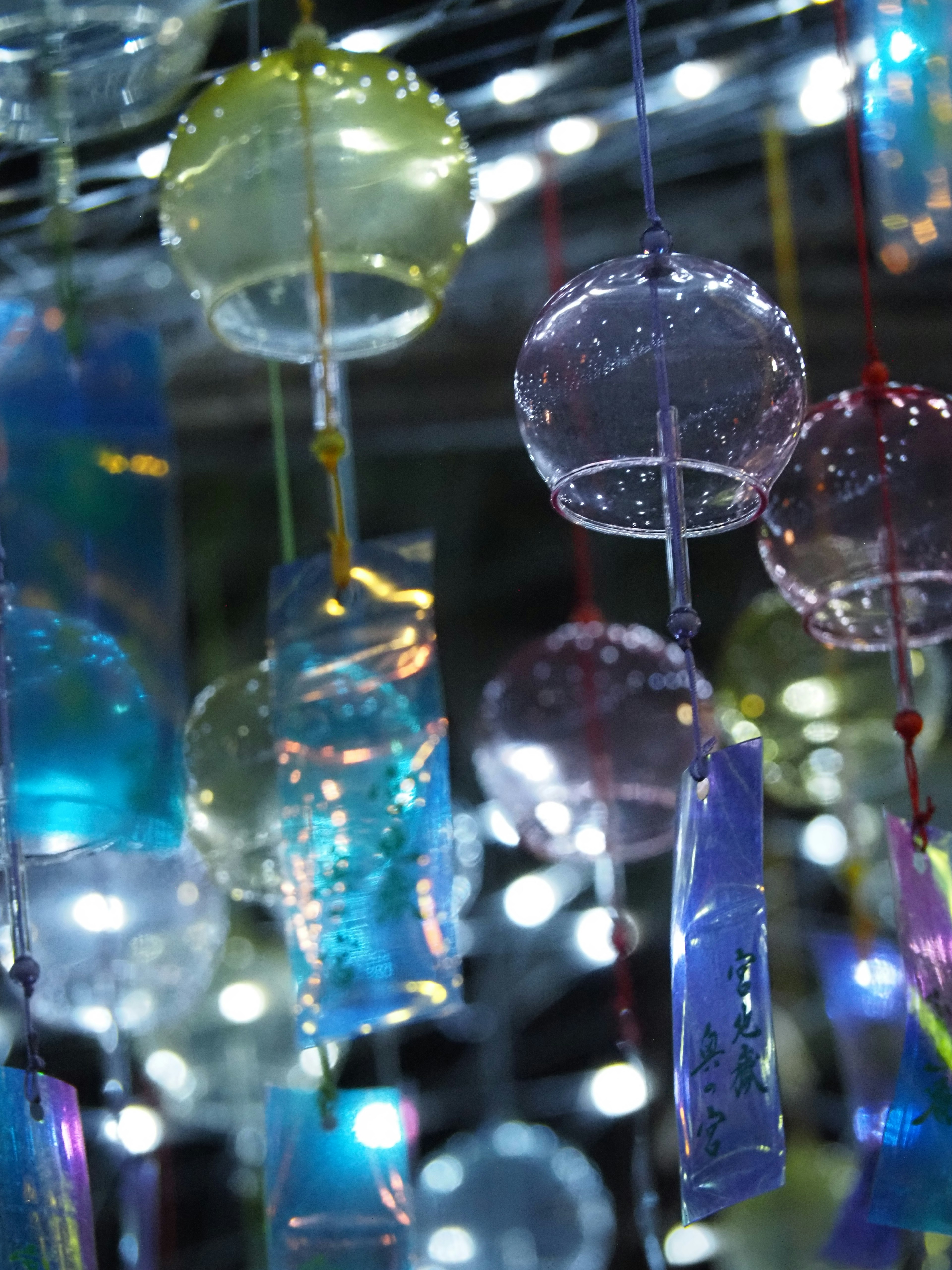 Colorful wind chimes hanging against a glowing background