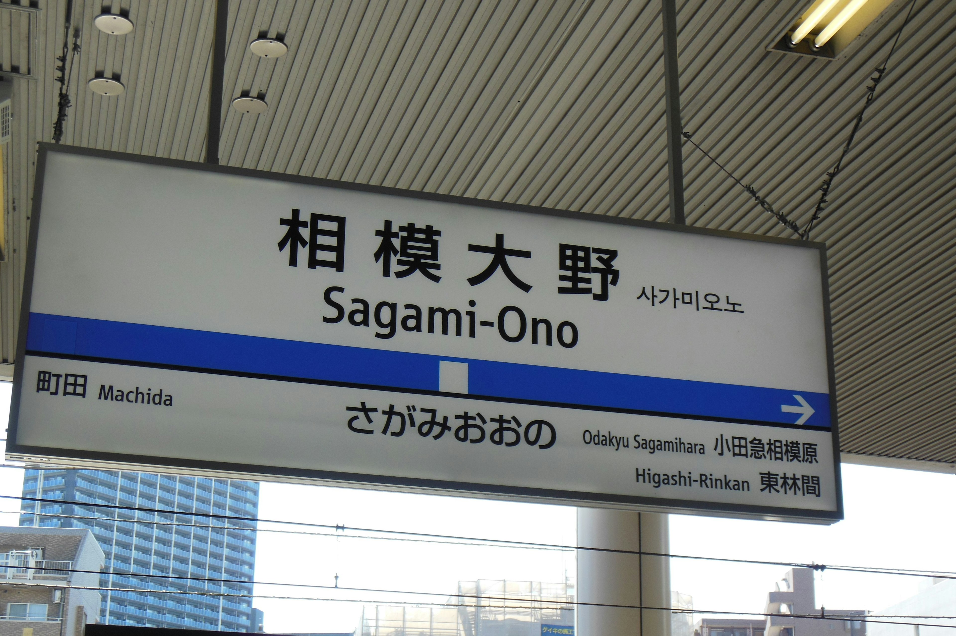 Cartel de la estación Sagami-Ono con texto en japonés e inglés