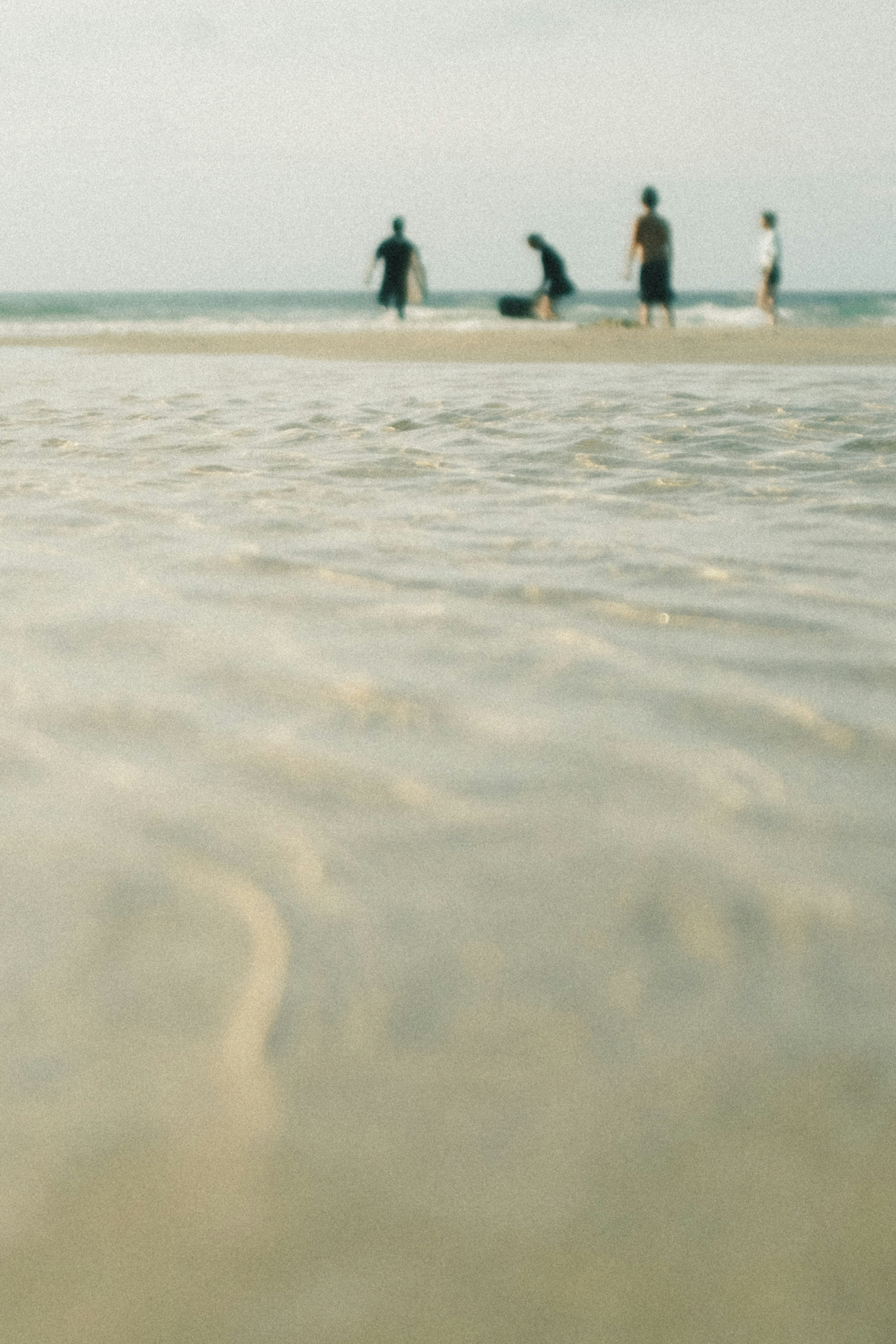 Persone che giocano sulla spiaggia con onde gentili