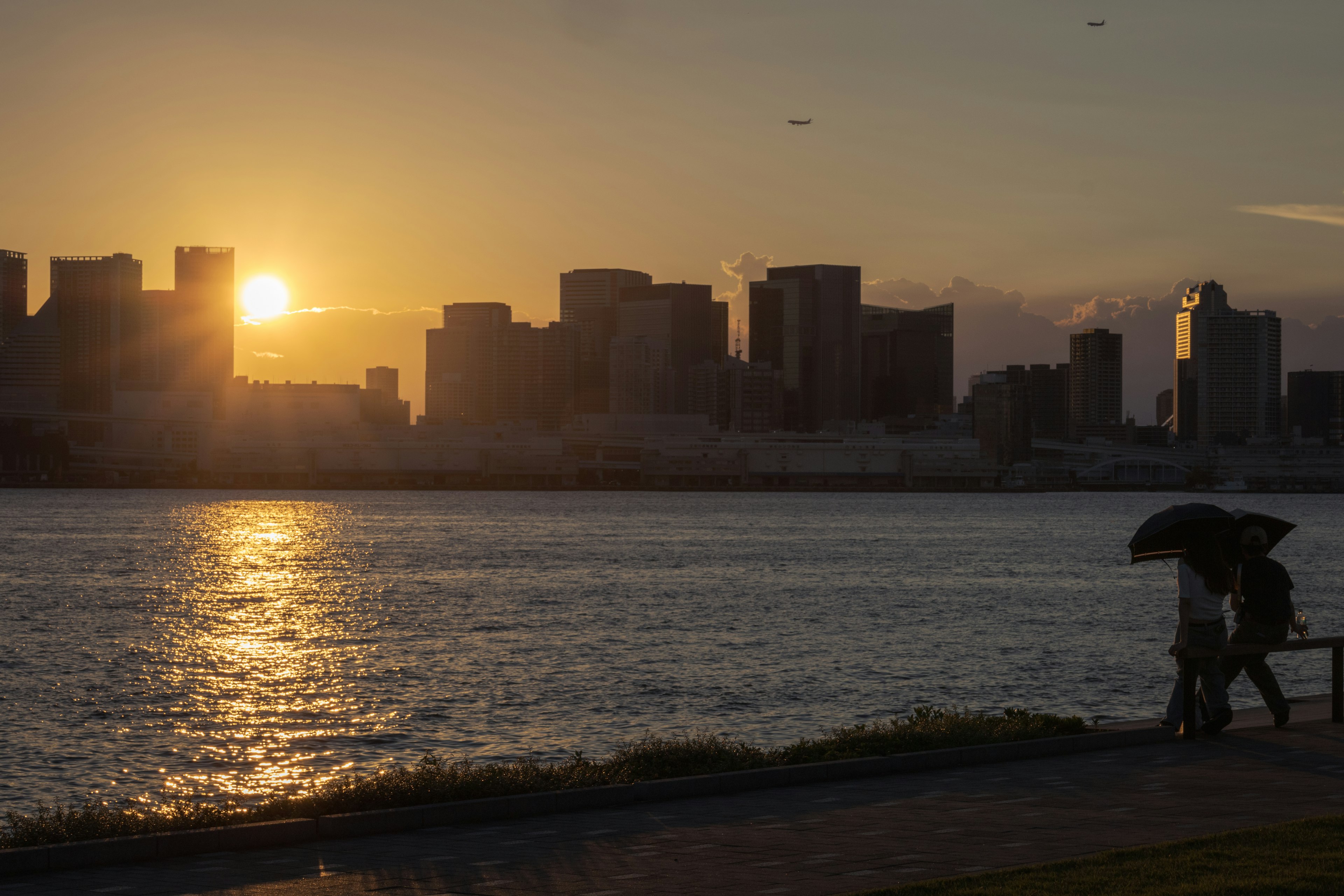 Silhouette of a city skyline at sunset with a river