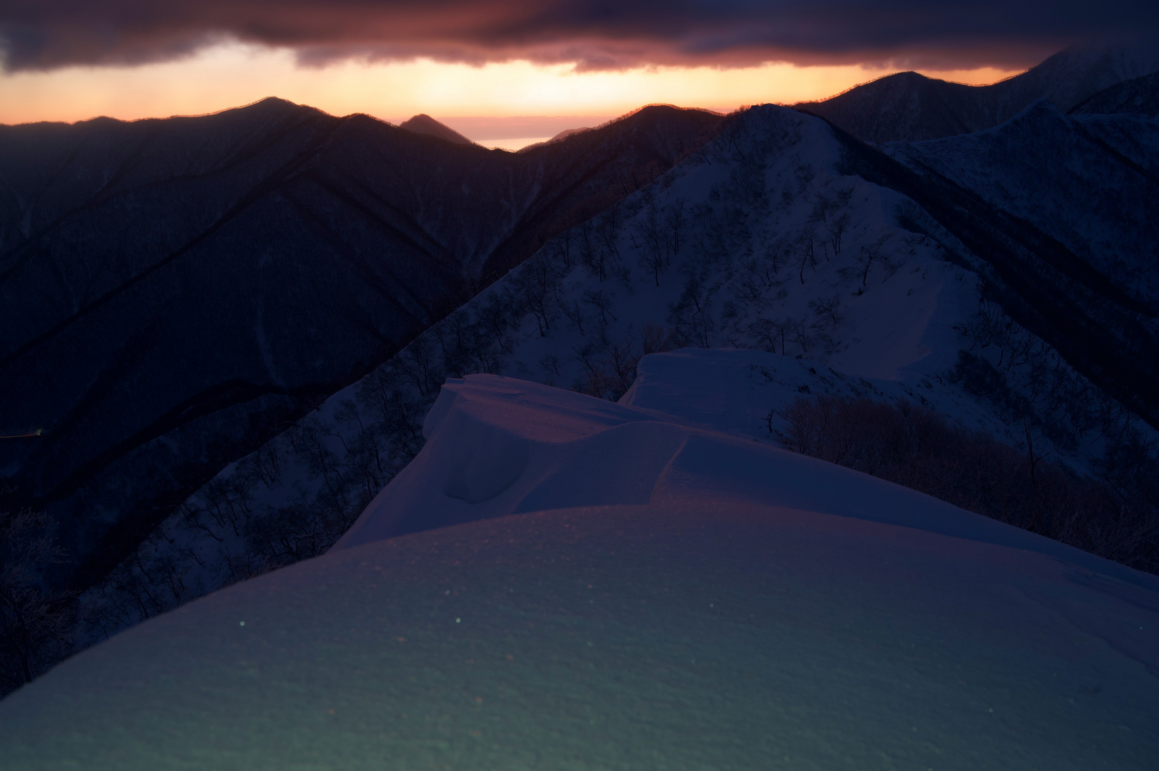 Atemberaubende Landschaft mit Bergsilhouetten, die vom Sonnenuntergang beleuchtet werden