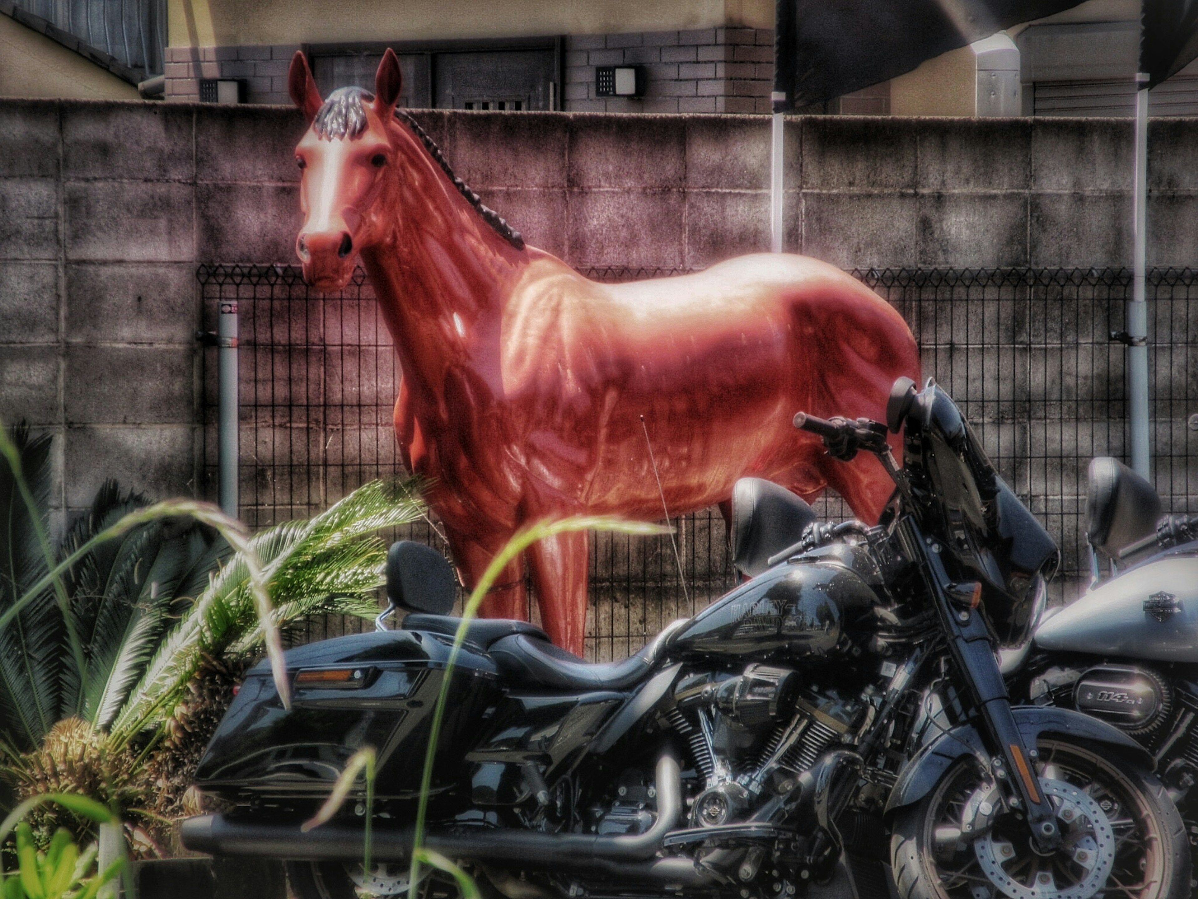 Un caballo rojo al lado de una motocicleta negra