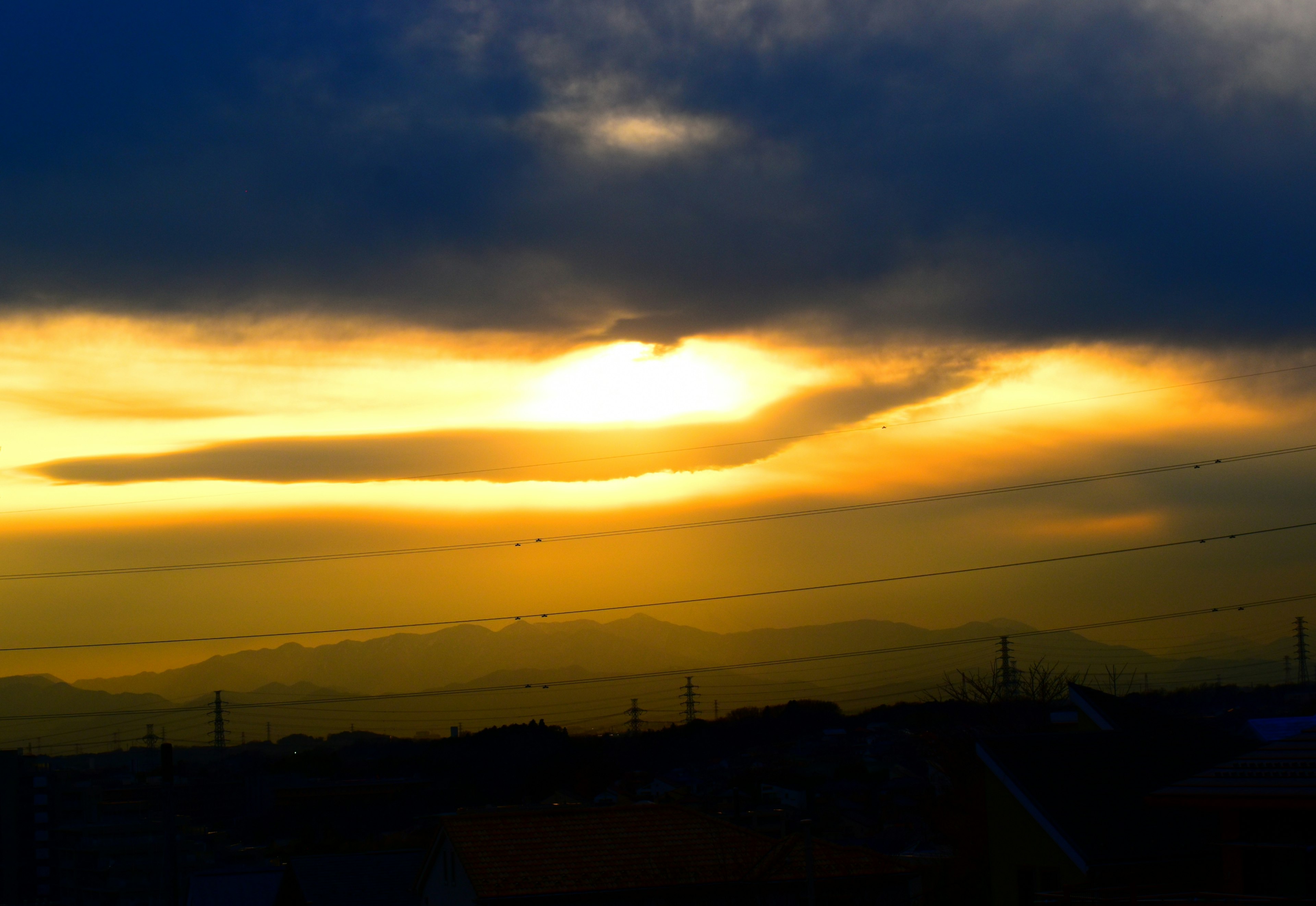 Coucher de soleil dramatique avec des nuages et des silhouettes de montagnes