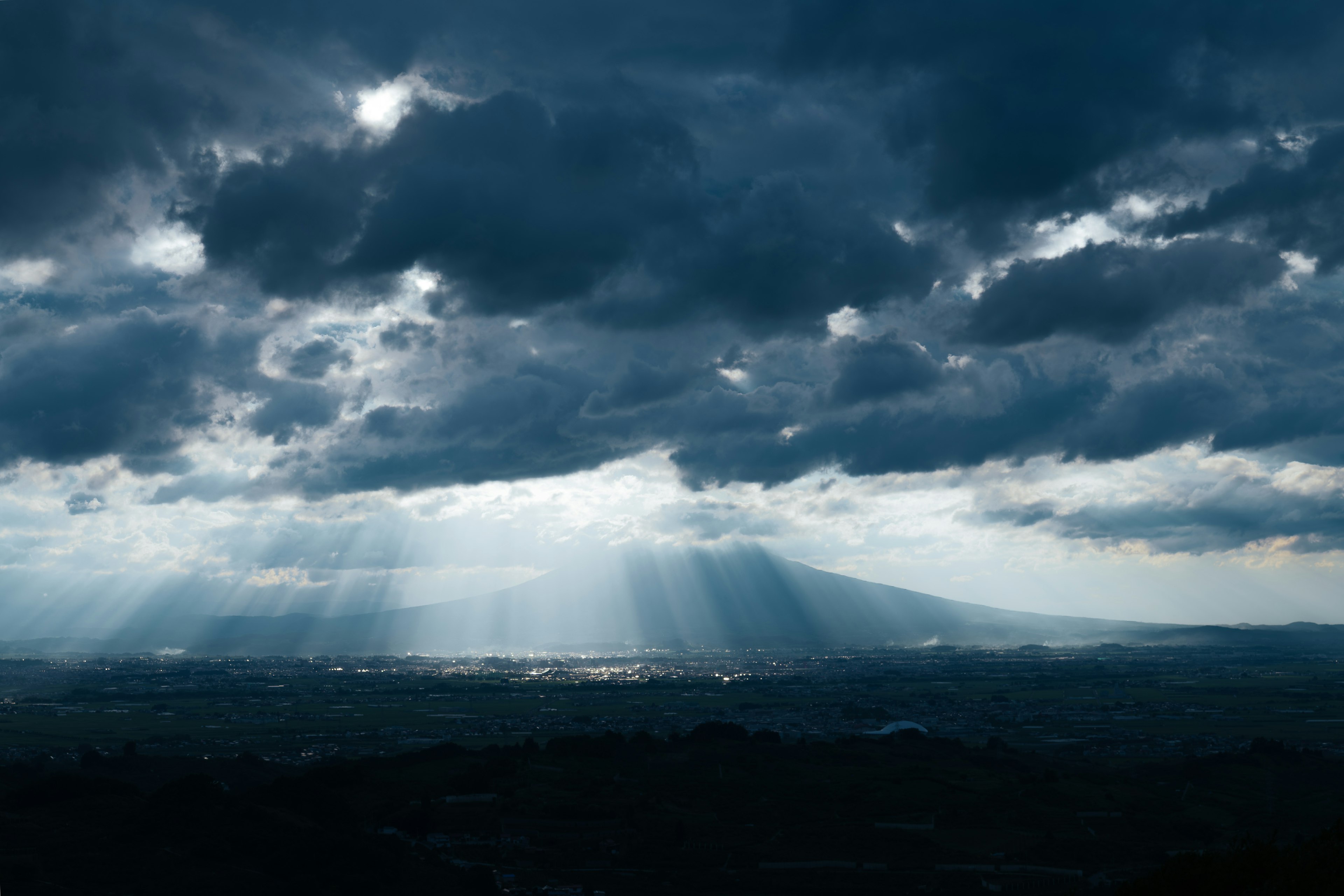 Nuvole drammatiche con raggi di sole che illuminano il paesaggio