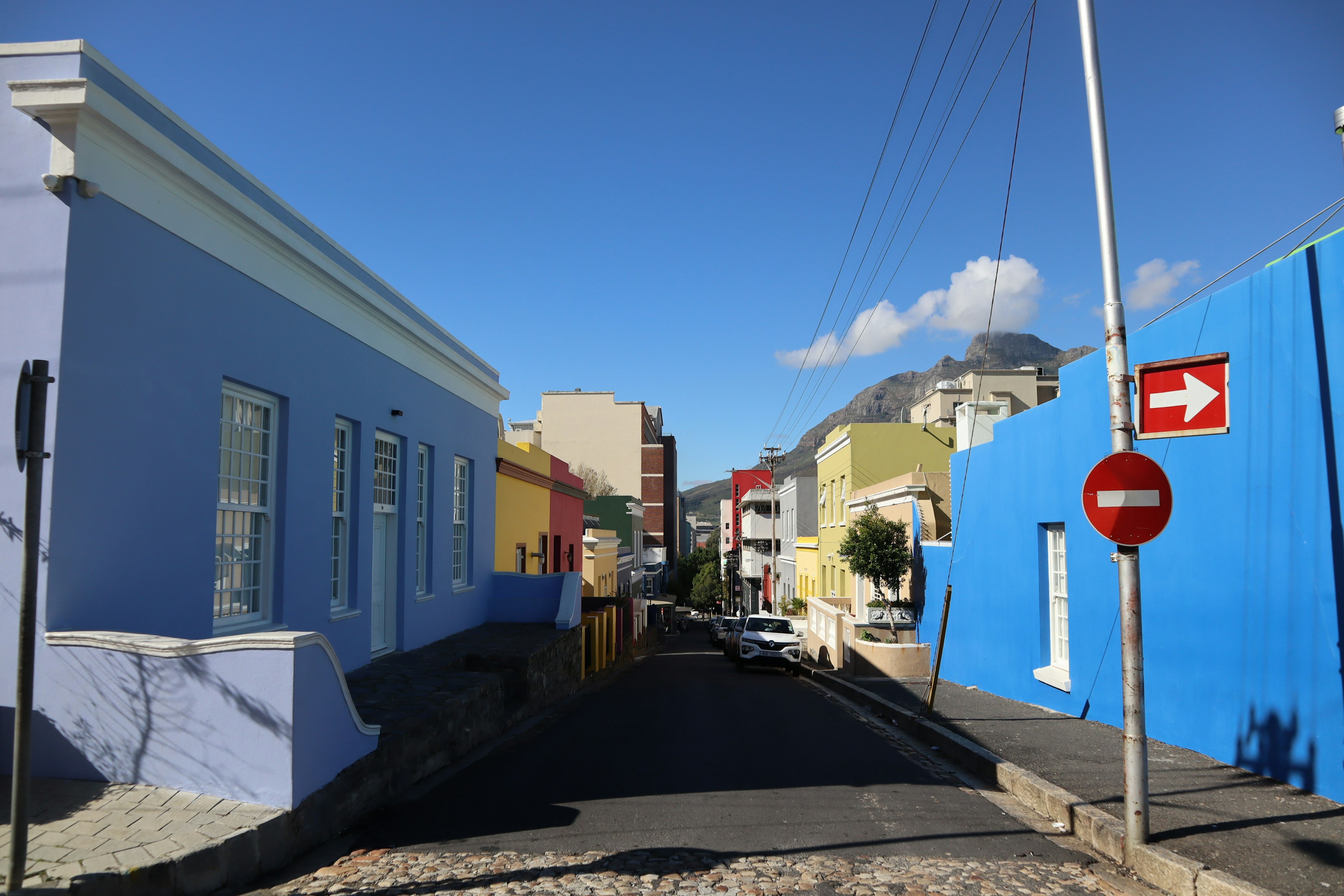 Colorful buildings lining a street under a clear blue sky