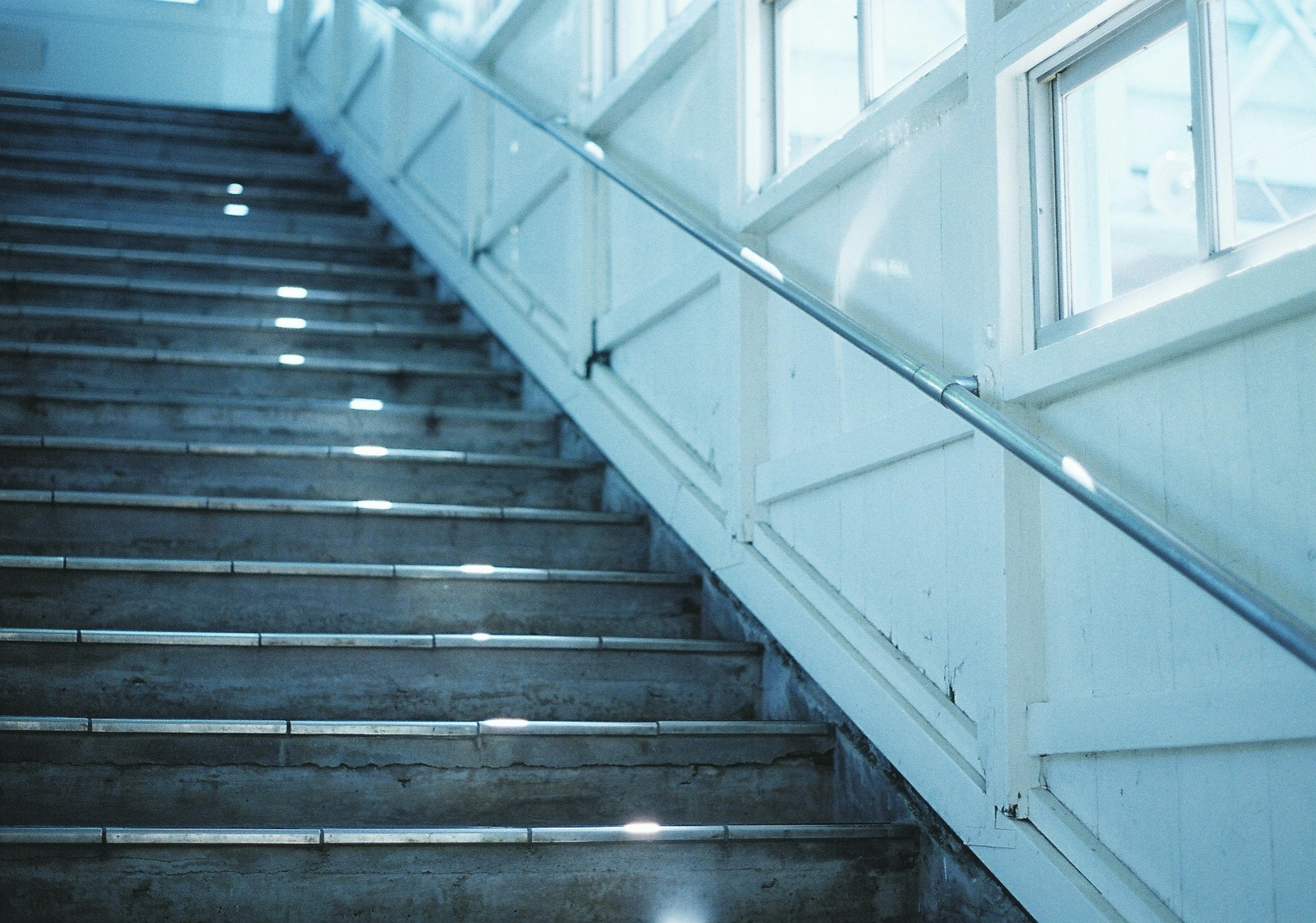 Escalera brillante con paredes blancas y ventanas