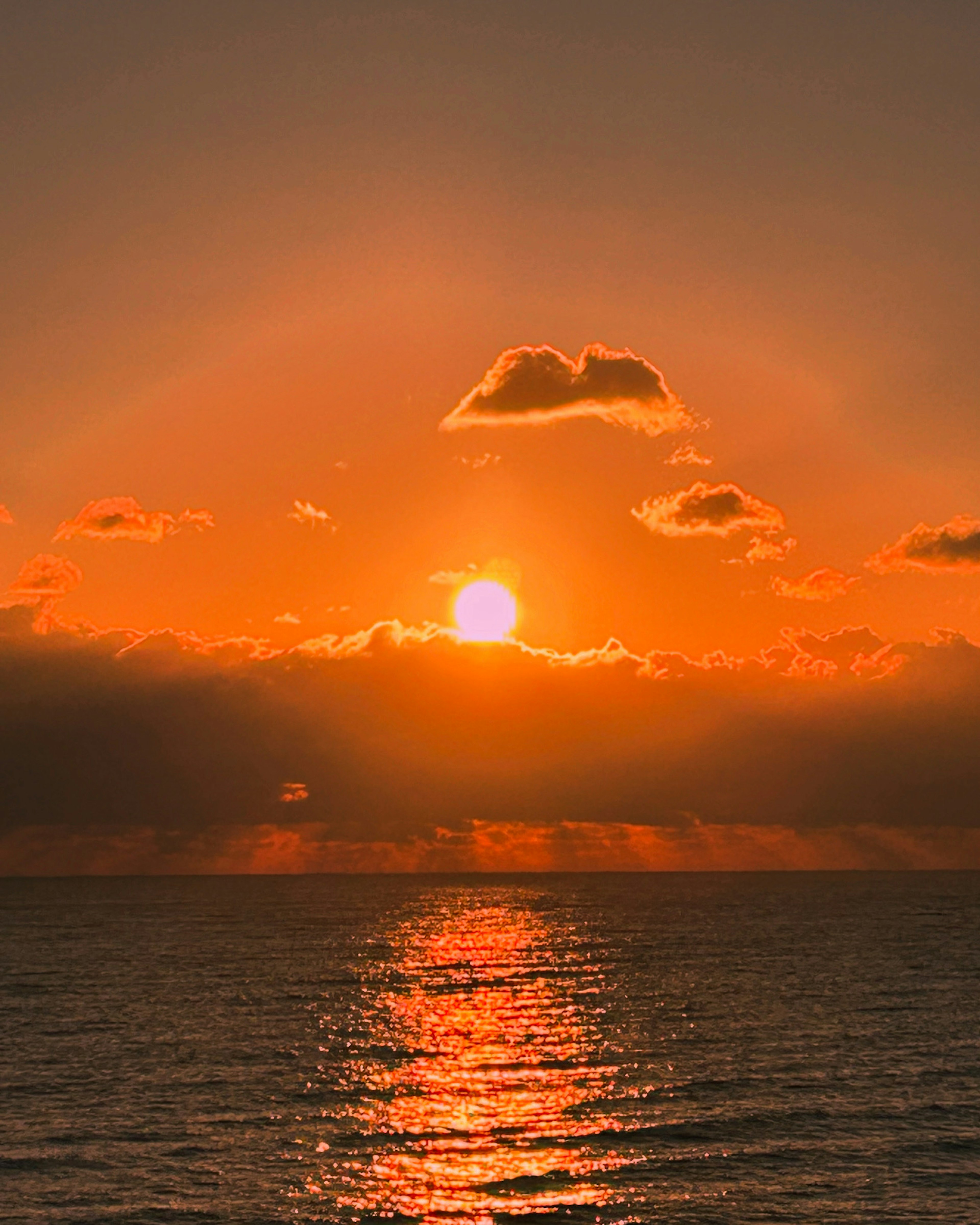 Un magnifique coucher de soleil avec un soleil orange se couchant à l'horizon de l'océan