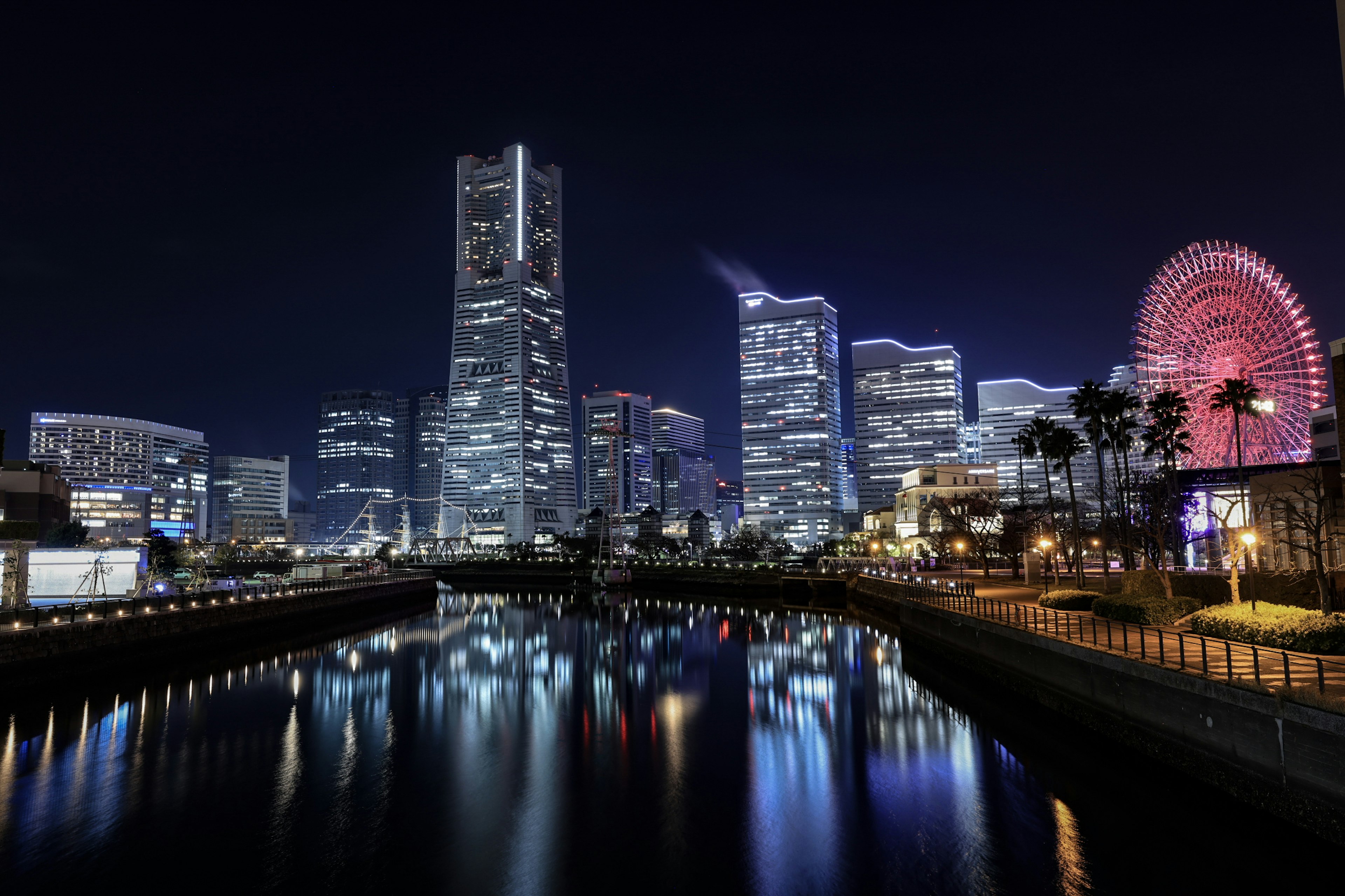 Pemandangan malam Yokohama dengan gedung pencakar langit dan roda ferris yang terpantul di air