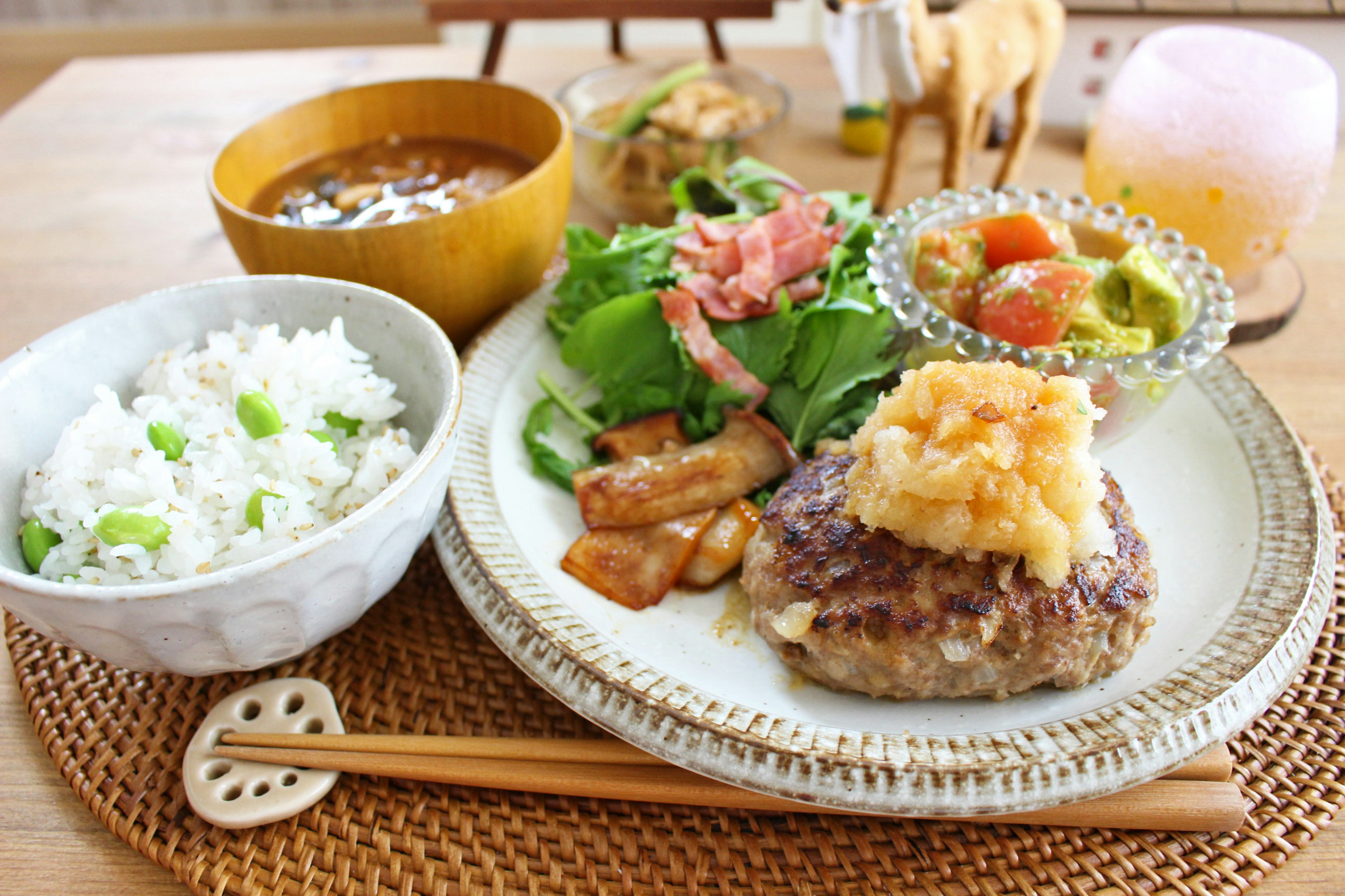 Disposición de comida al estilo japonés con hamburguesa, arroz blanco, ensalada y sopa de miso