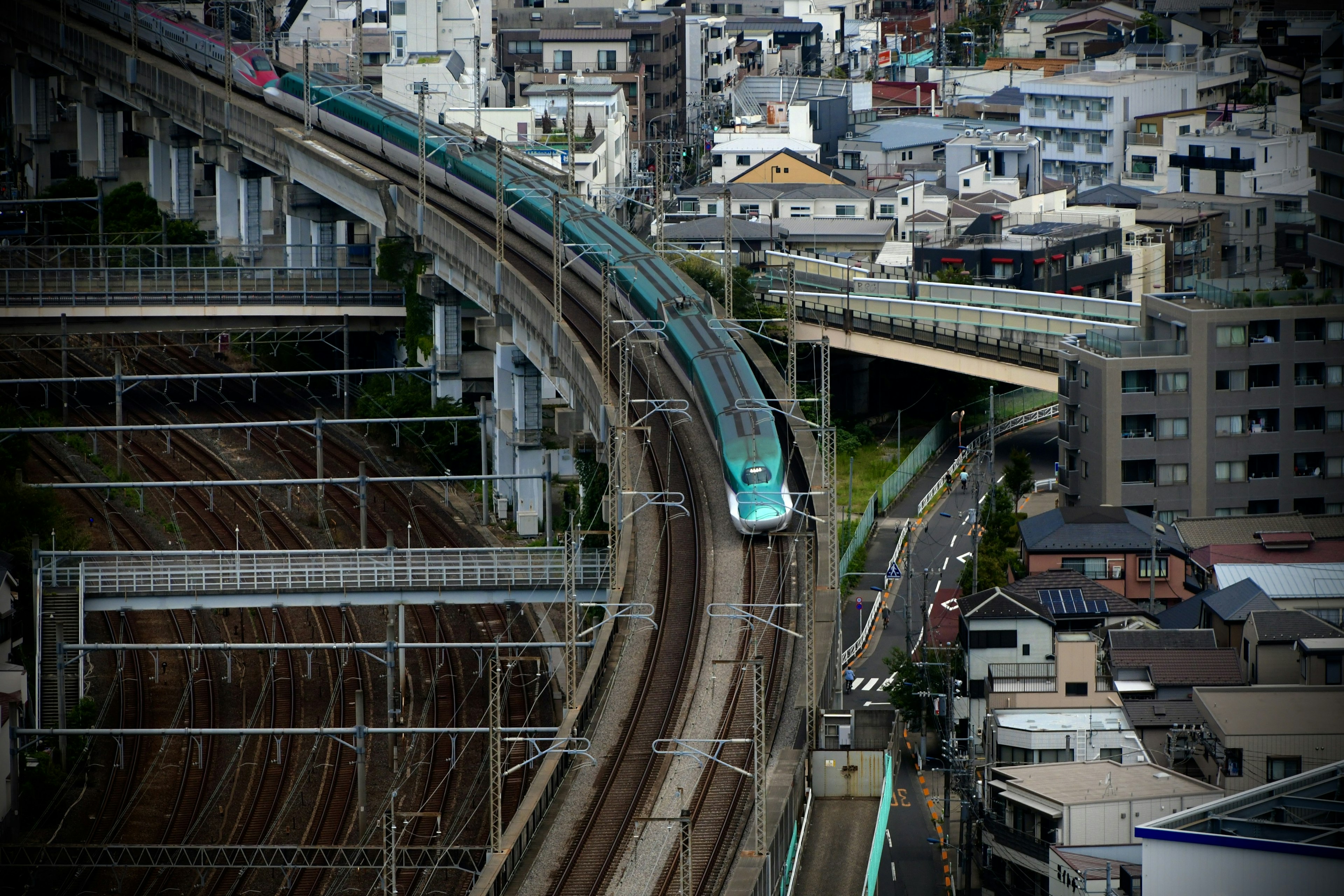 Vía de tren elevada en curva con paisaje urbano circundante