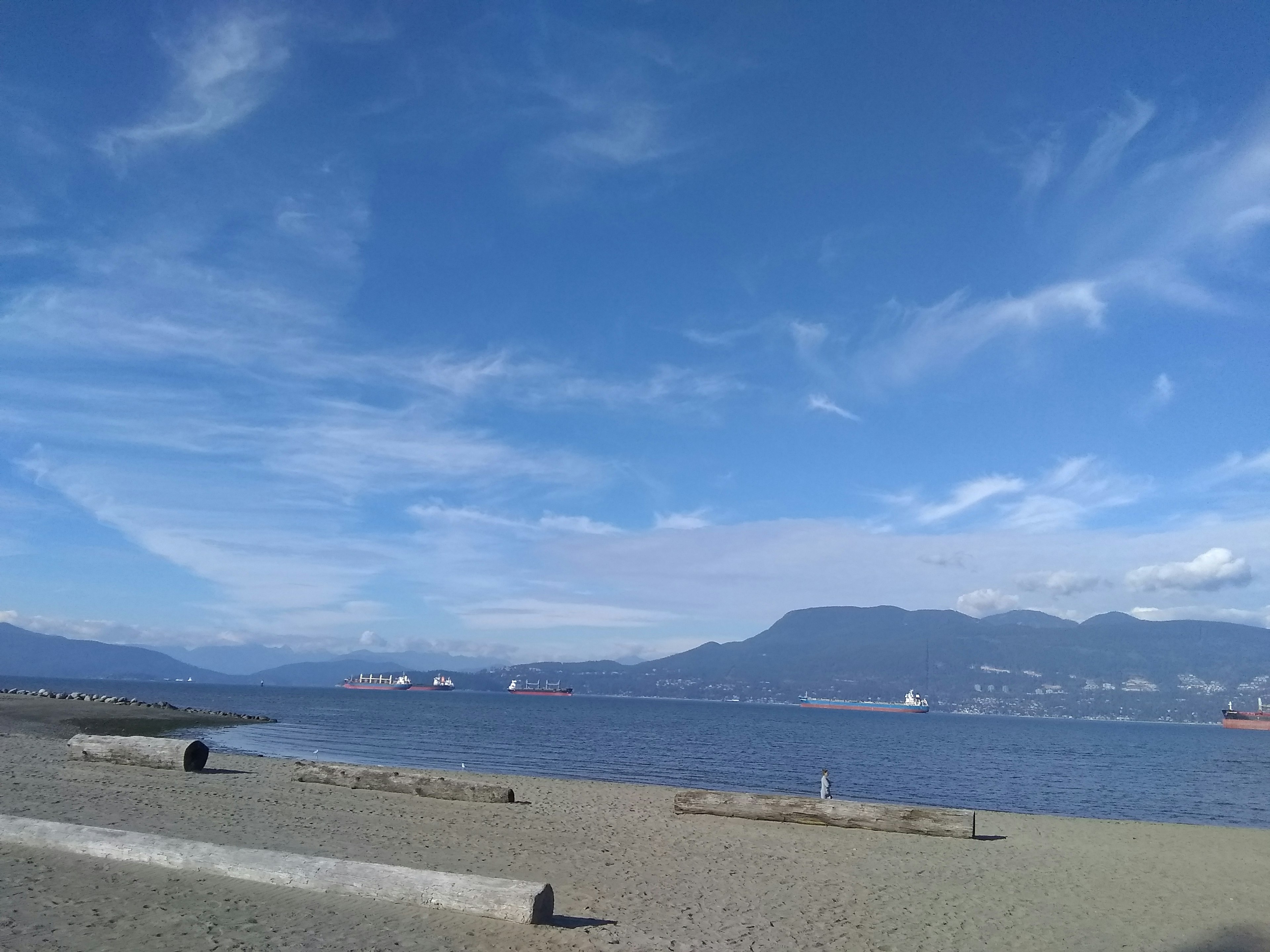 Pemandangan pantai dengan langit biru dan gunung jauh