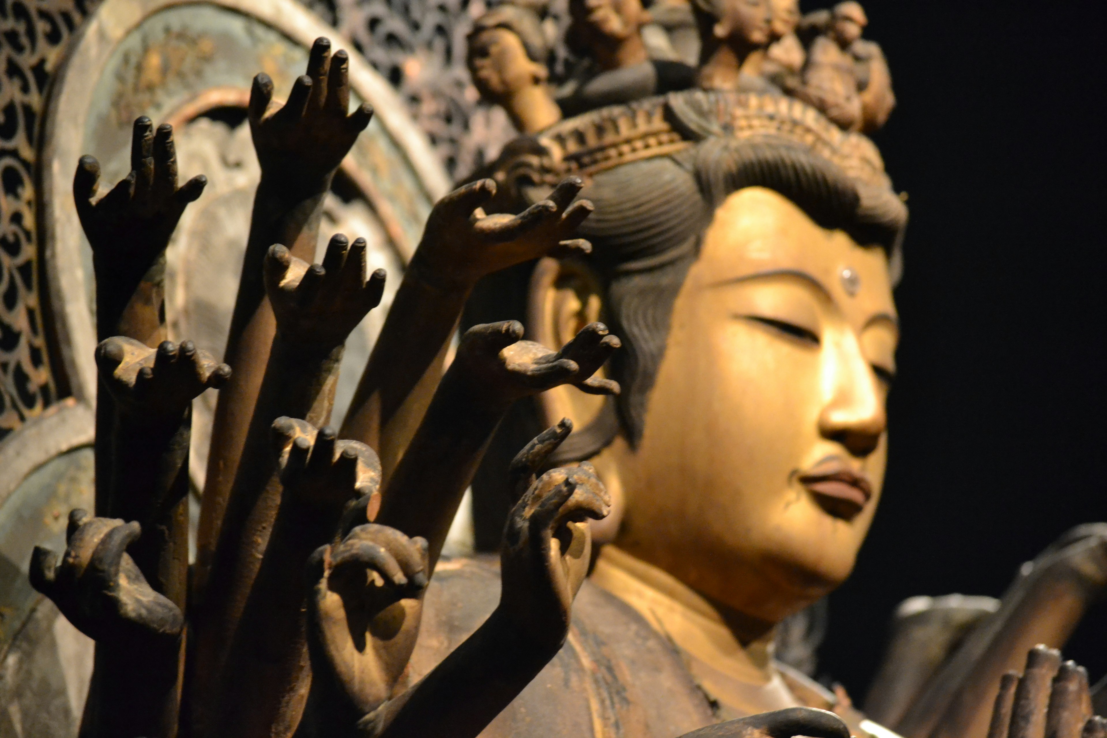 Close-up of a statue with many hands and a serene face