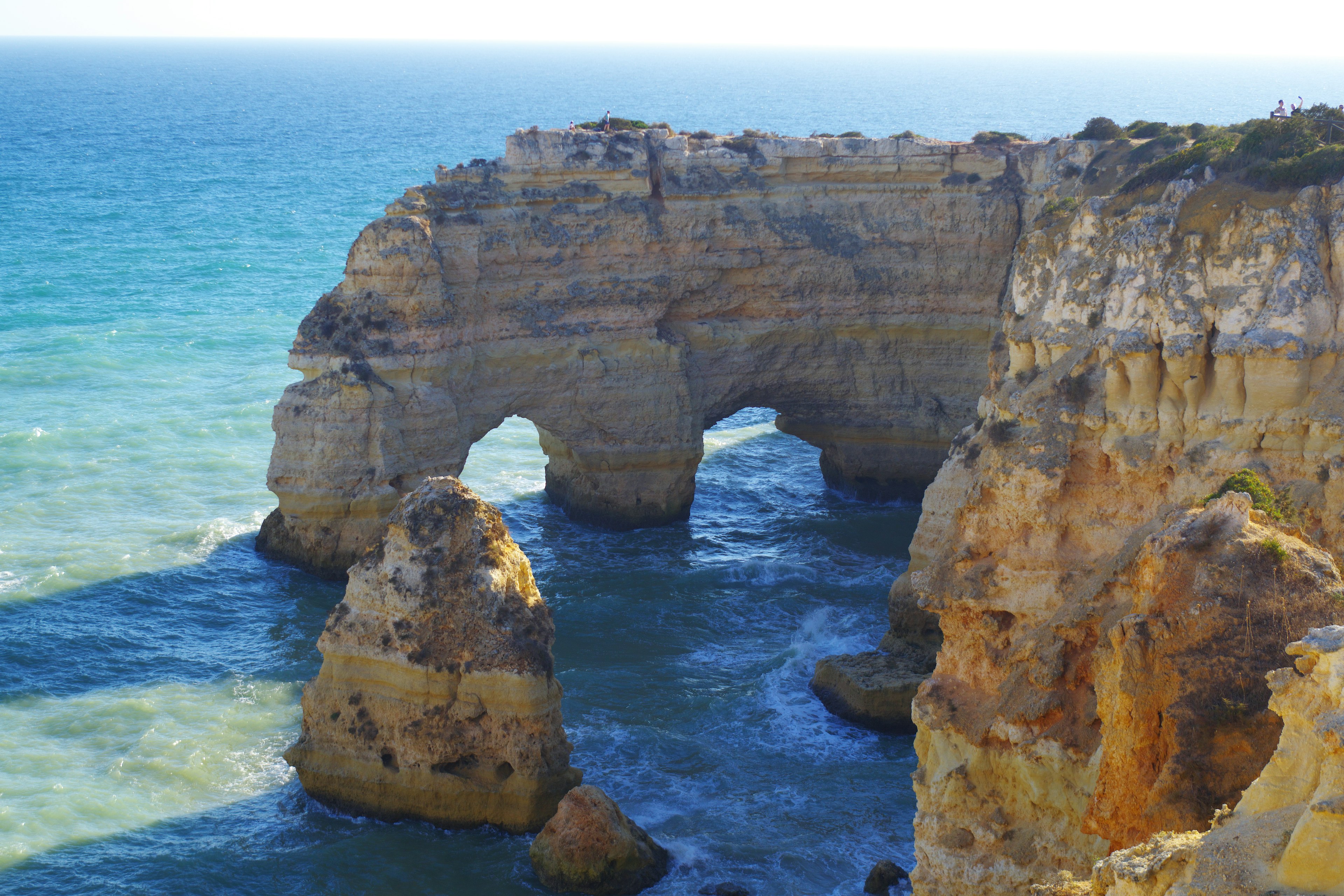 Scenic coastal rock arch with blue ocean waves