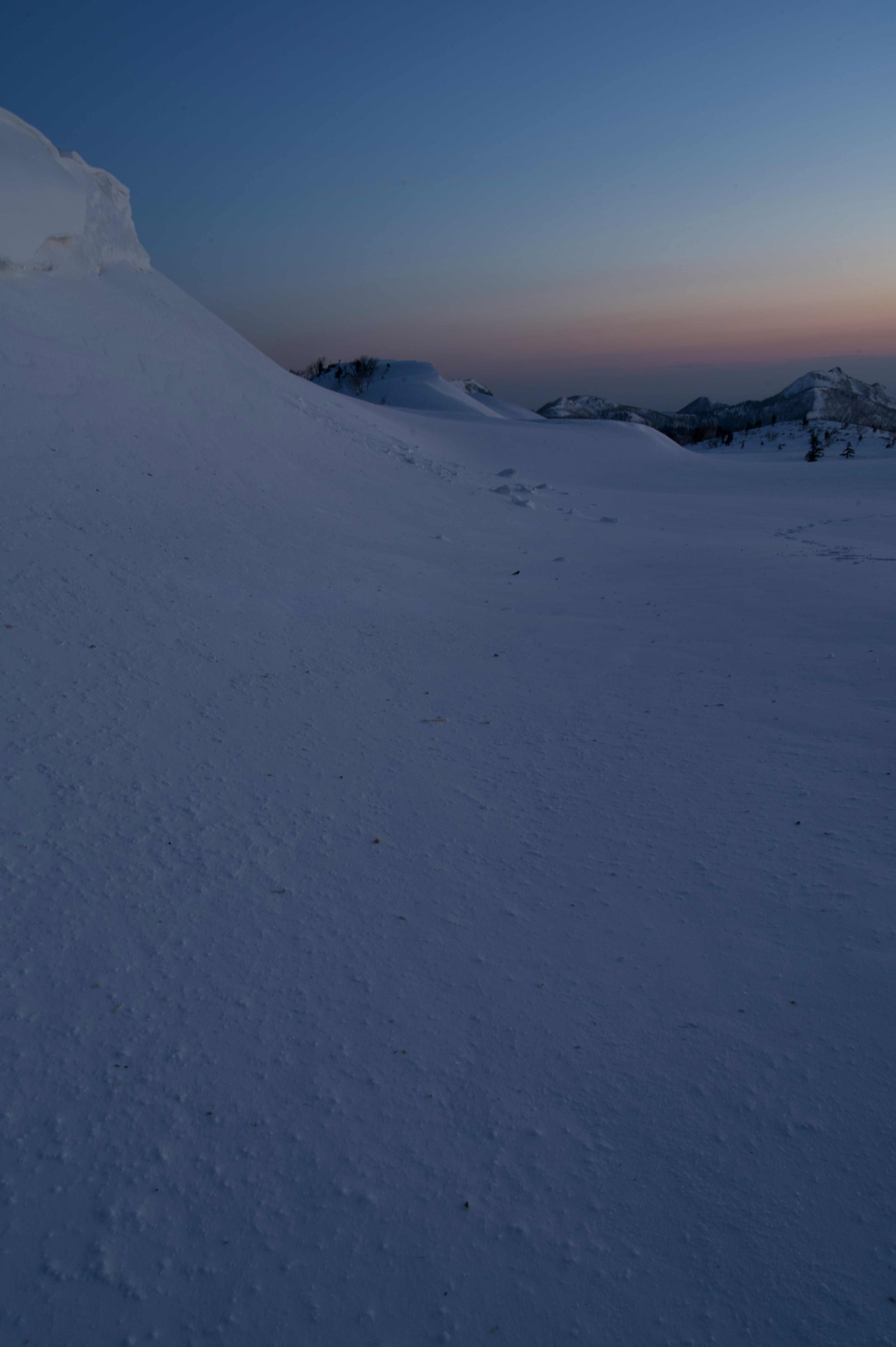 雪に覆われた山の景色と薄明かりの空