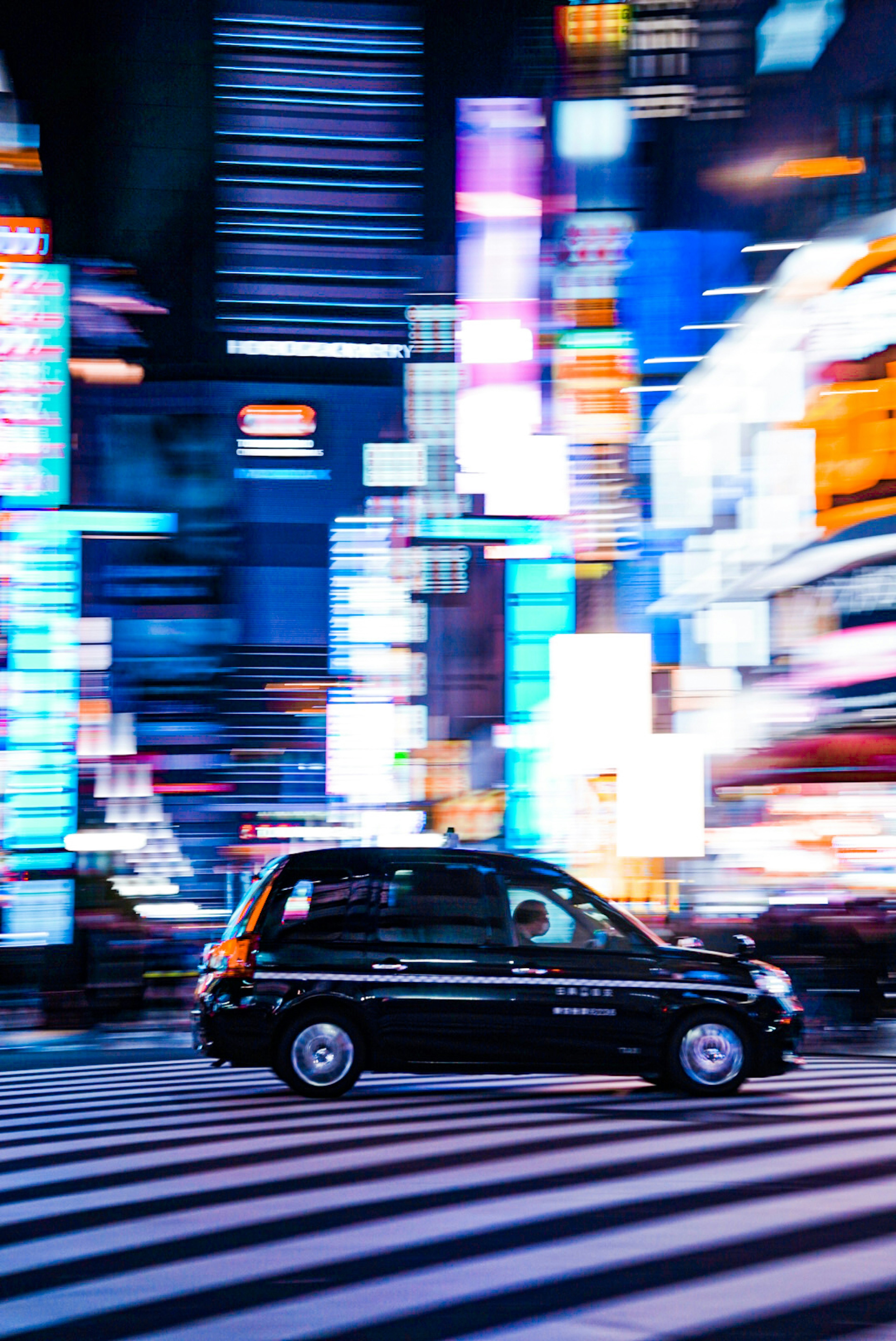 Black taxi driving through a vibrant city at night with colorful neon lights