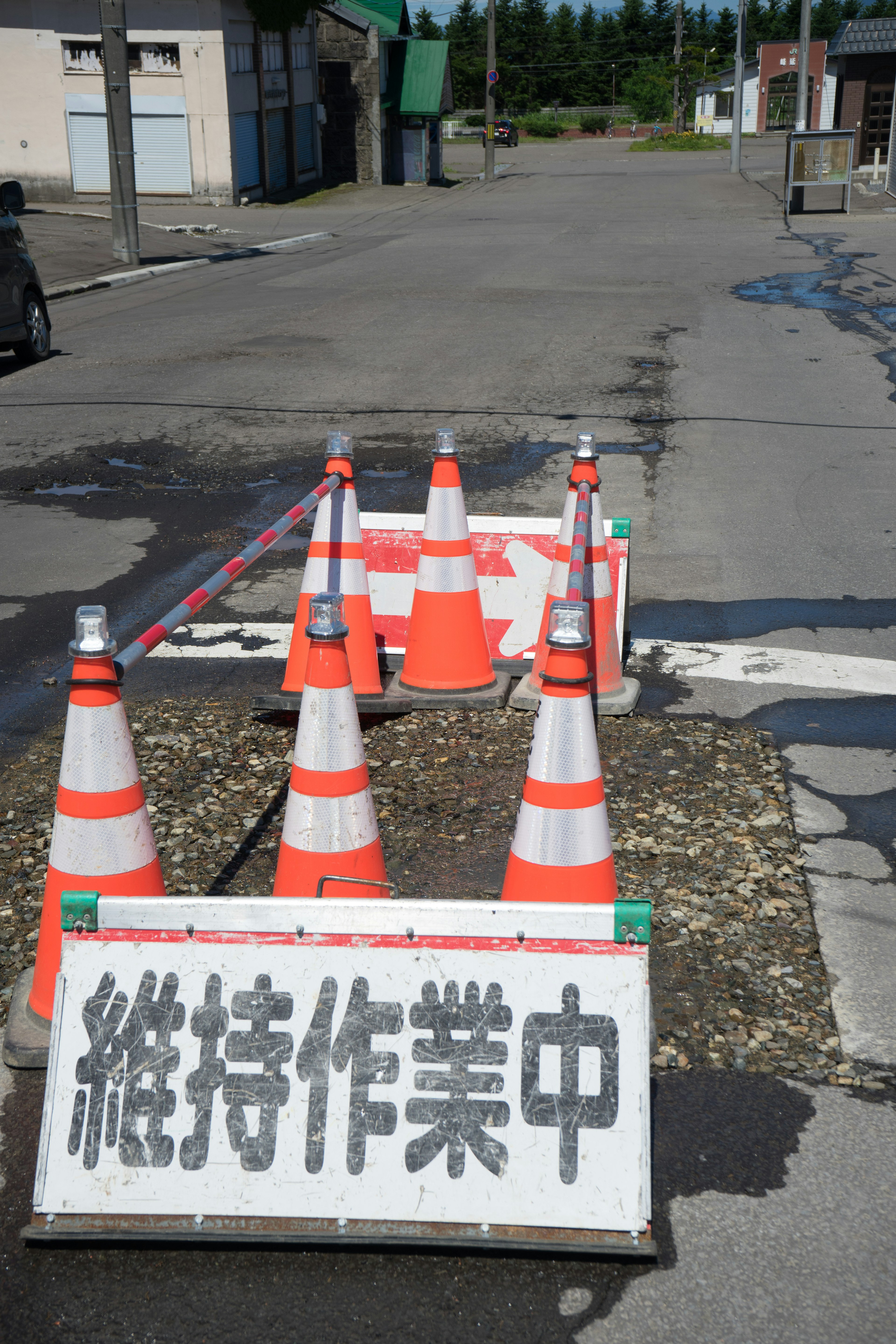 Señal de construcción con conos naranjas bloqueando una carretera