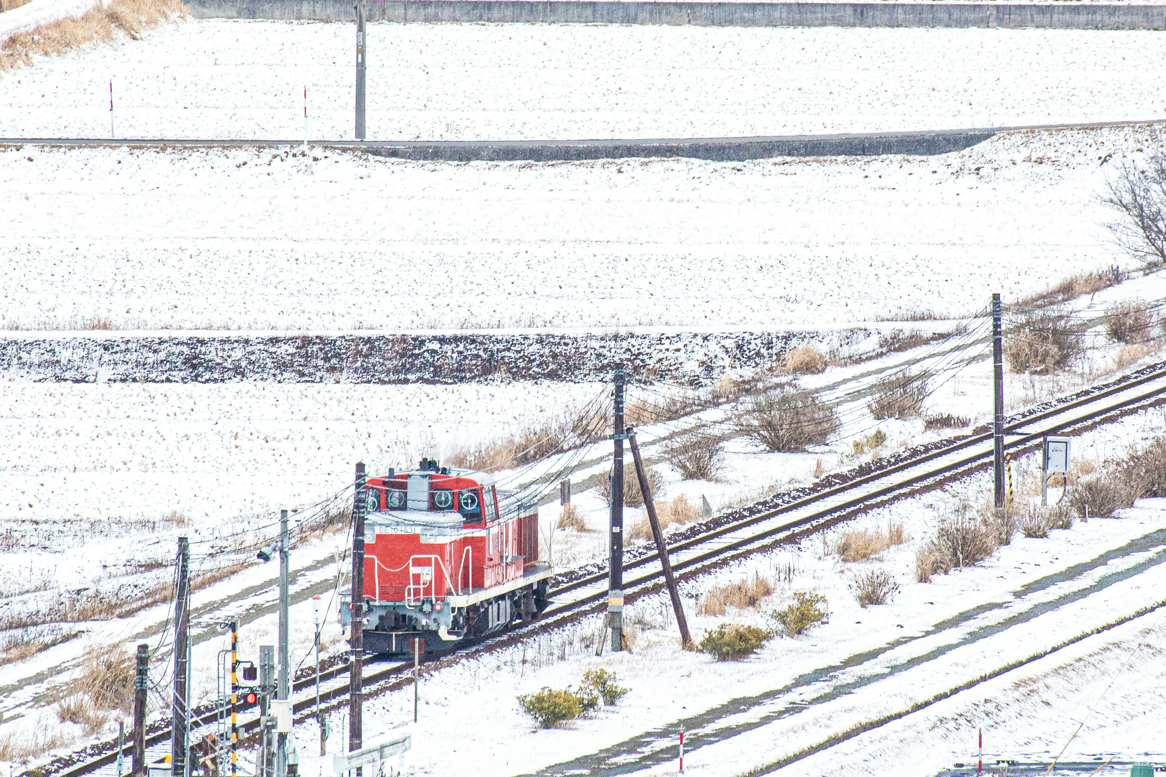 雪に覆われた鉄道の上を走る赤い機関車