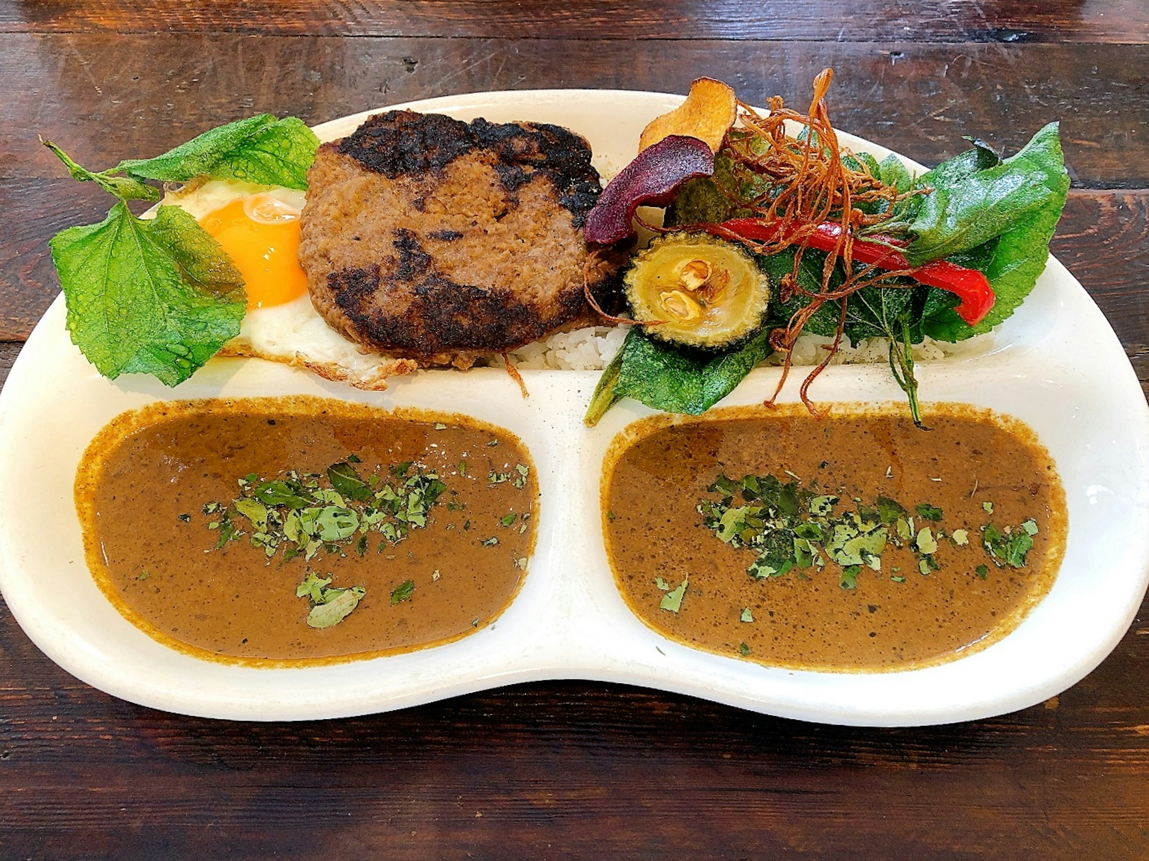 Un plato delicioso de comida que incluye curry picante, carne a la parrilla y verduras variadas