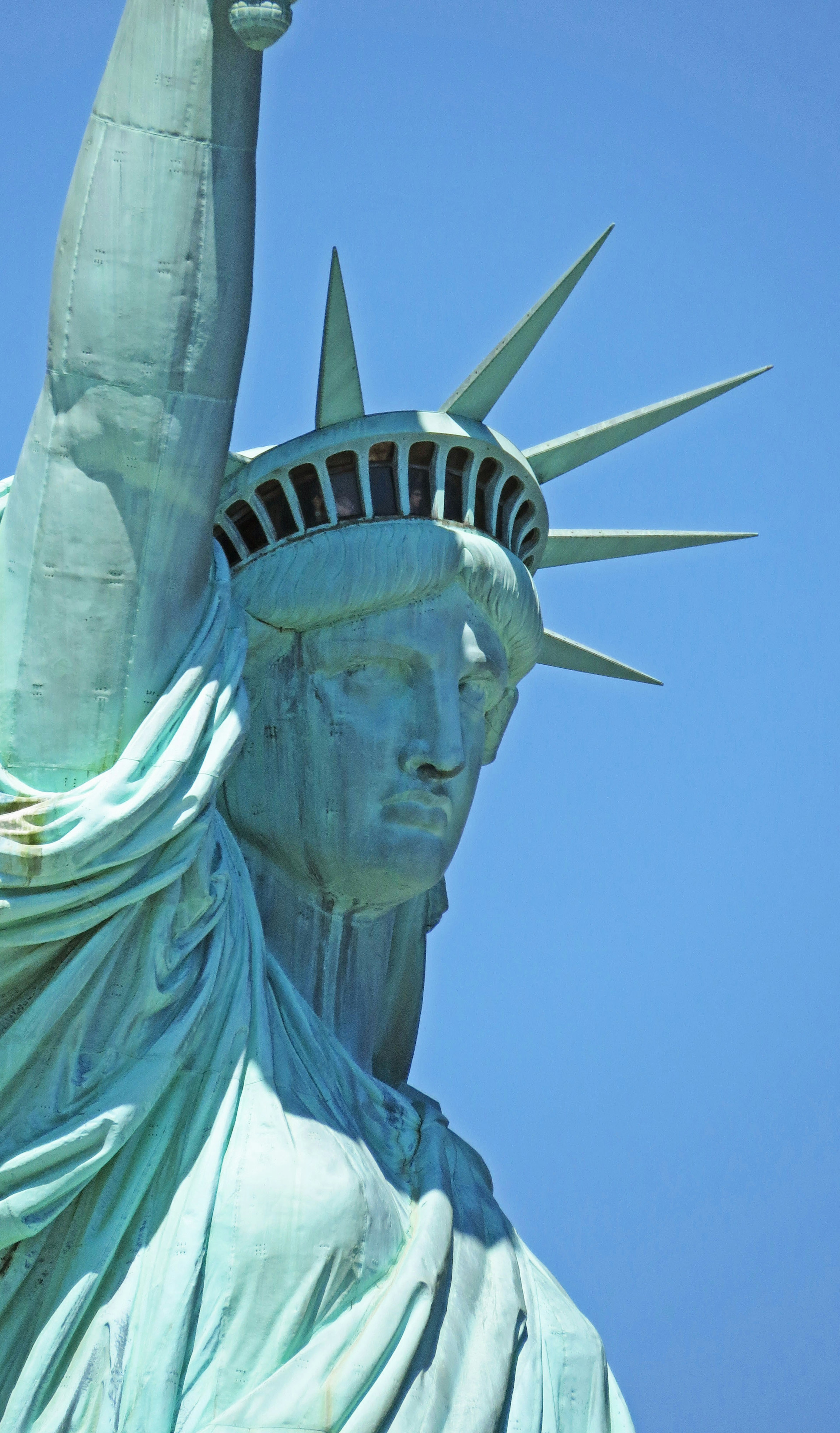 Close-up of the Statue of Liberty greenish statue against a blue sky