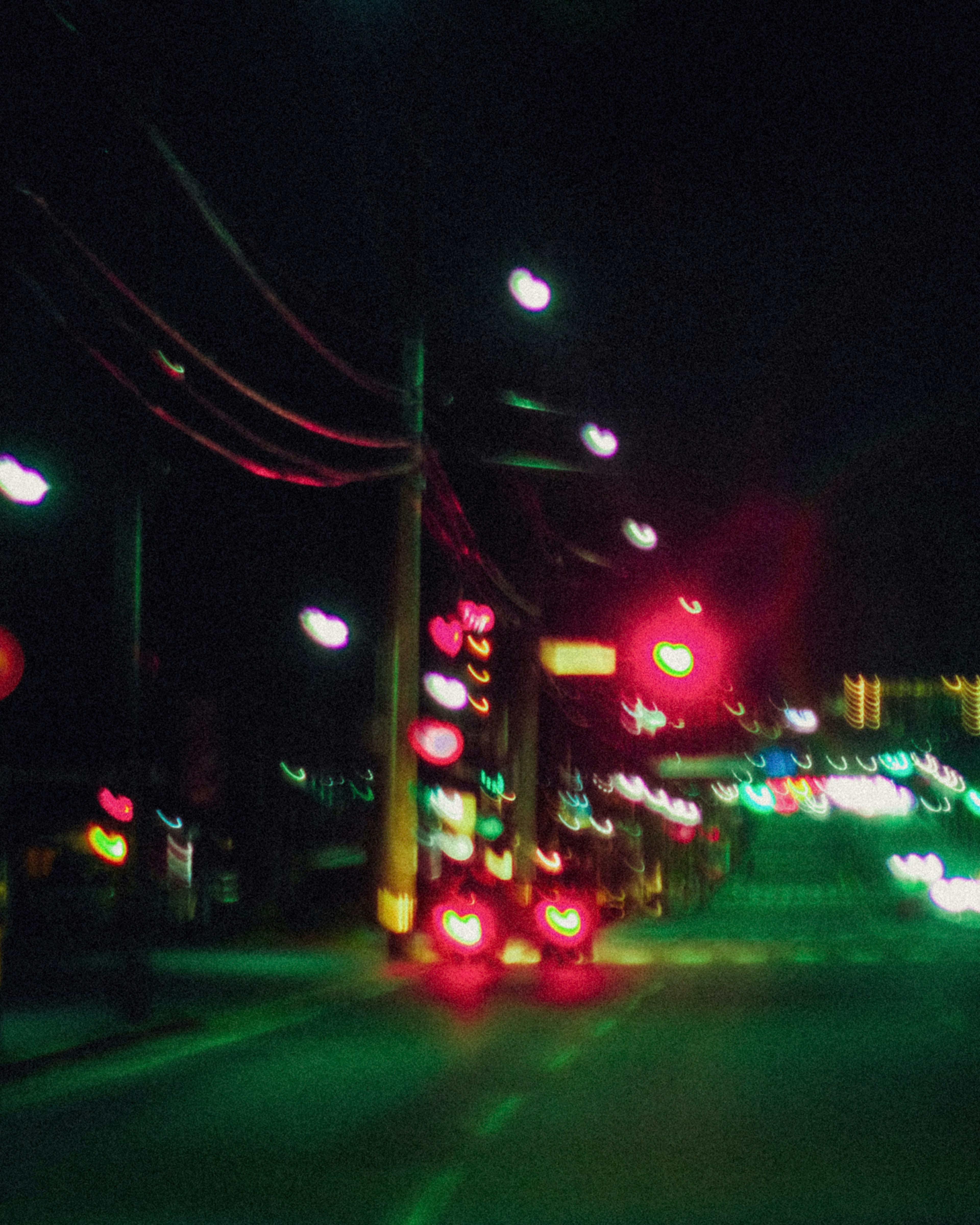 Nighttime street scene with illuminated streetlights and traffic signals