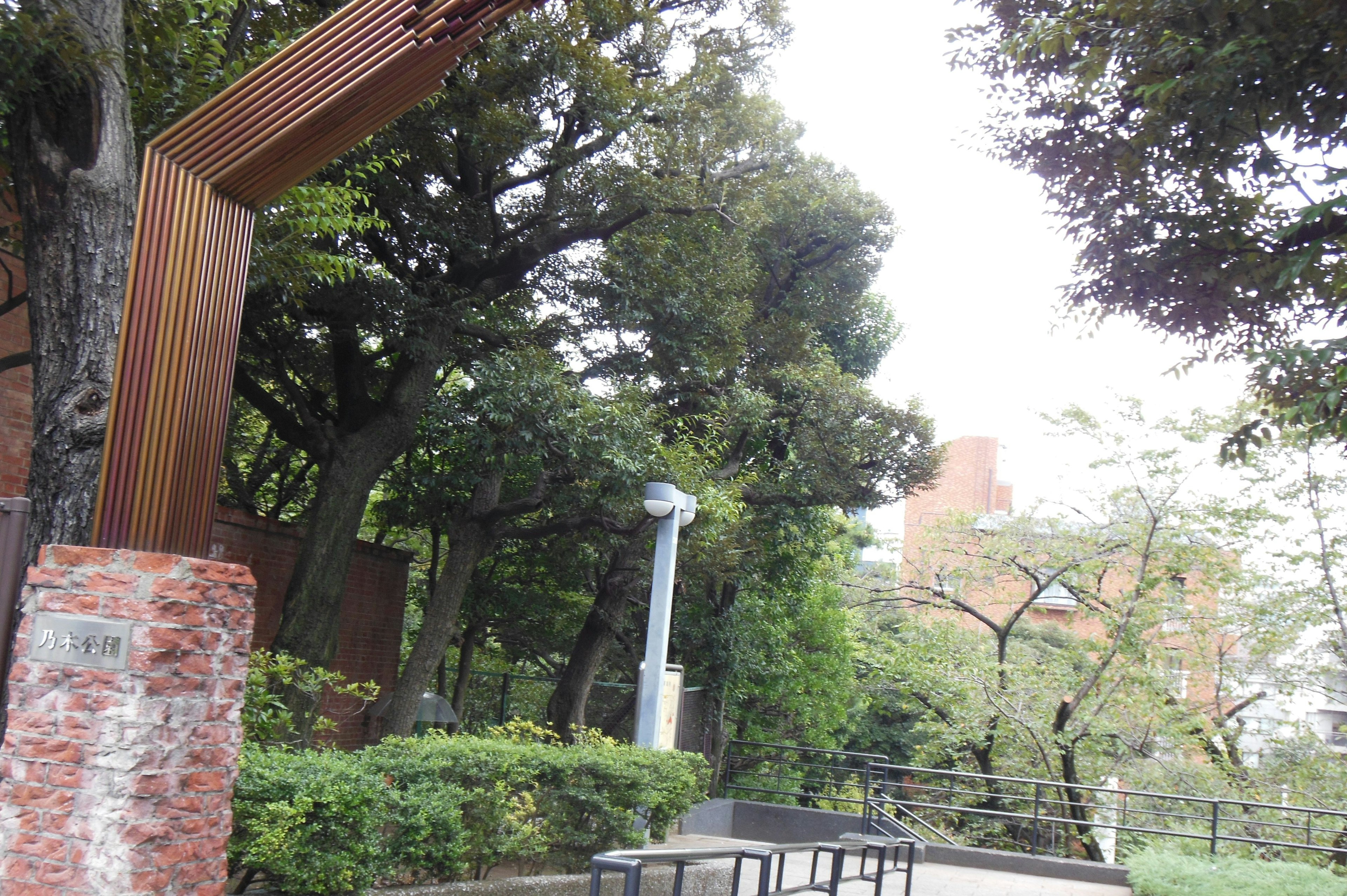 Un paisaje con árboles y un arco artístico en un parque