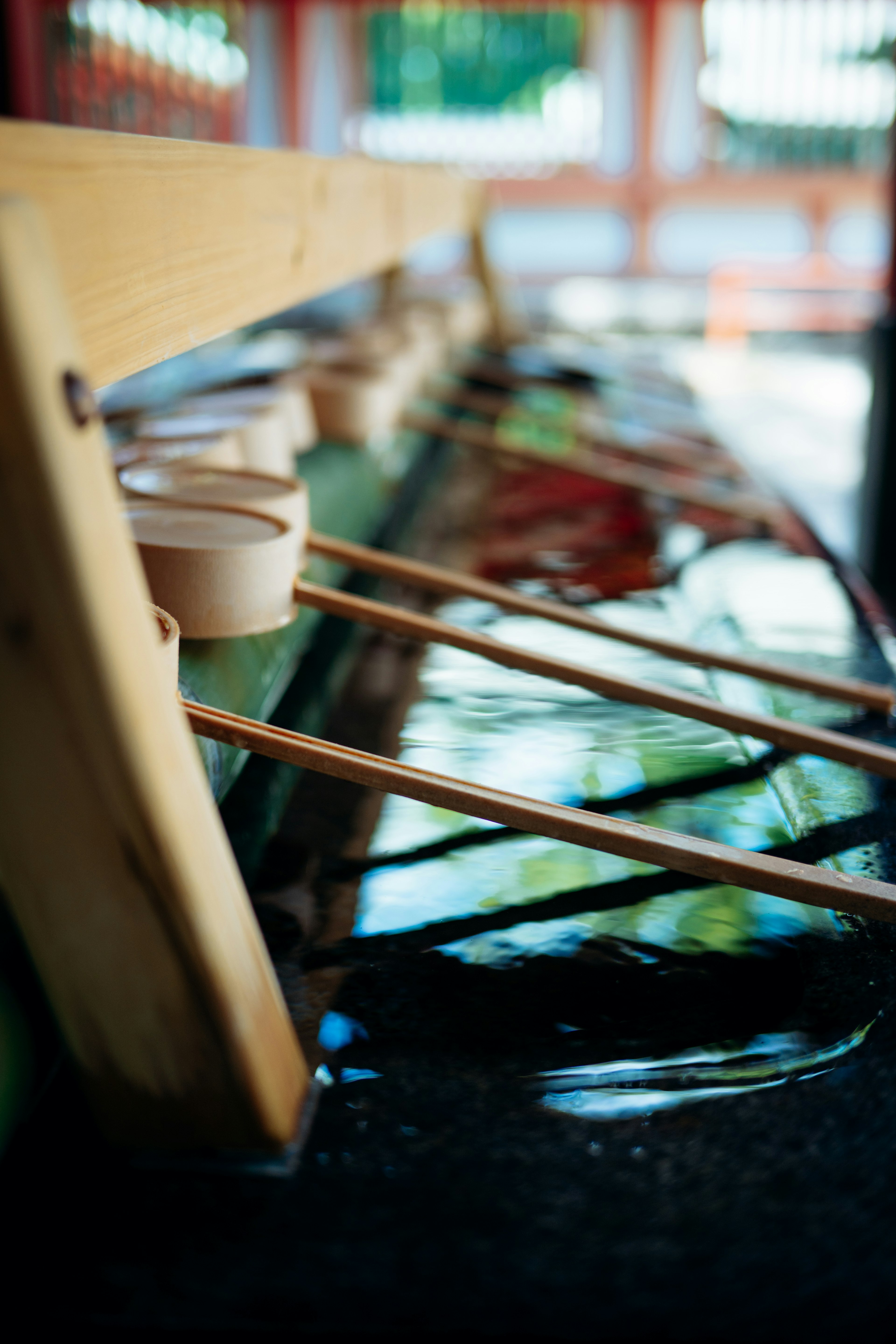 Fuente de purificación sintoísta con cucharas de madera y agua fluyendo