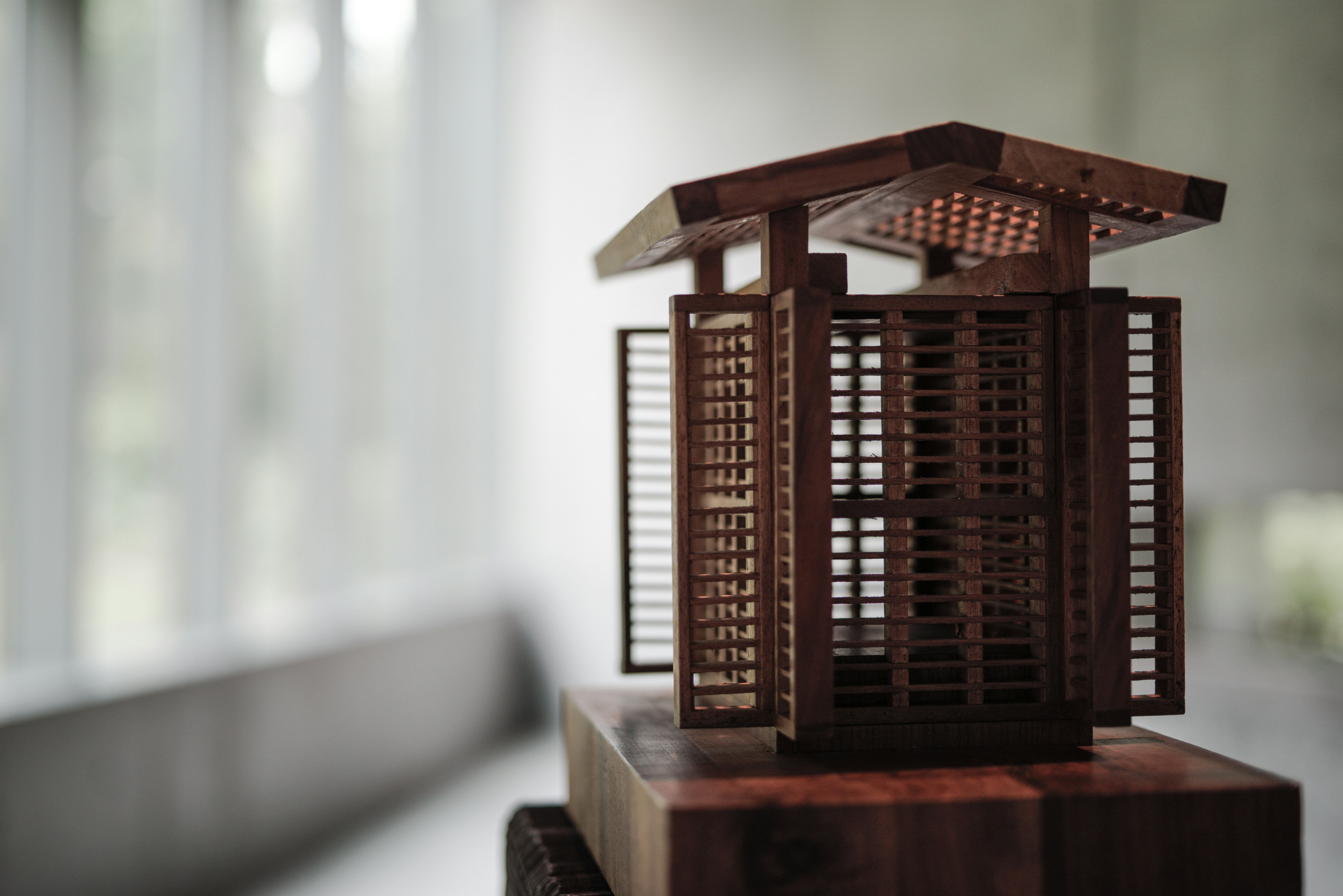 Struktur miniatur kayu dengan atap slatted dan desain detail