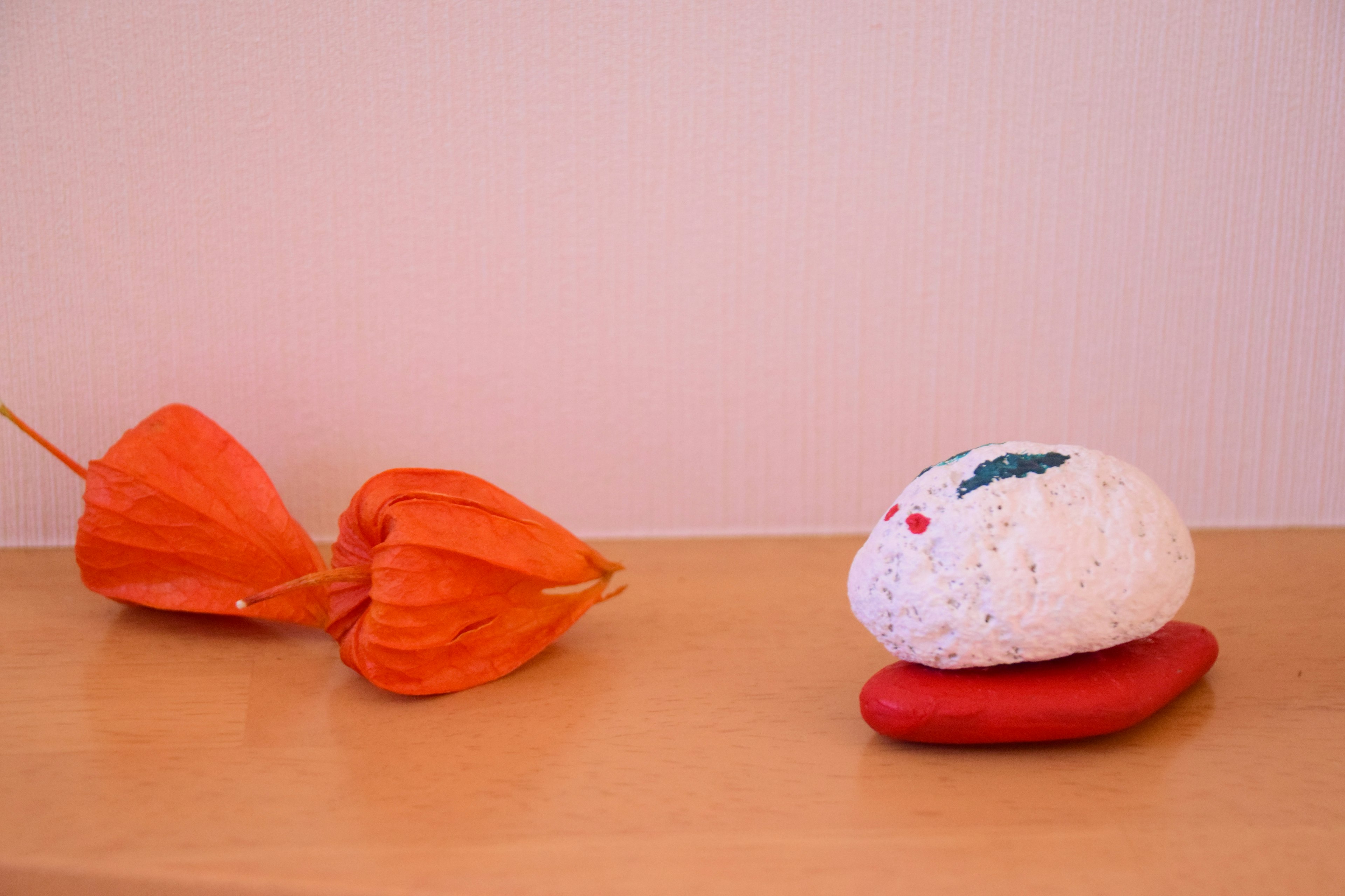 Decorative white stone on a red base next to orange flowers