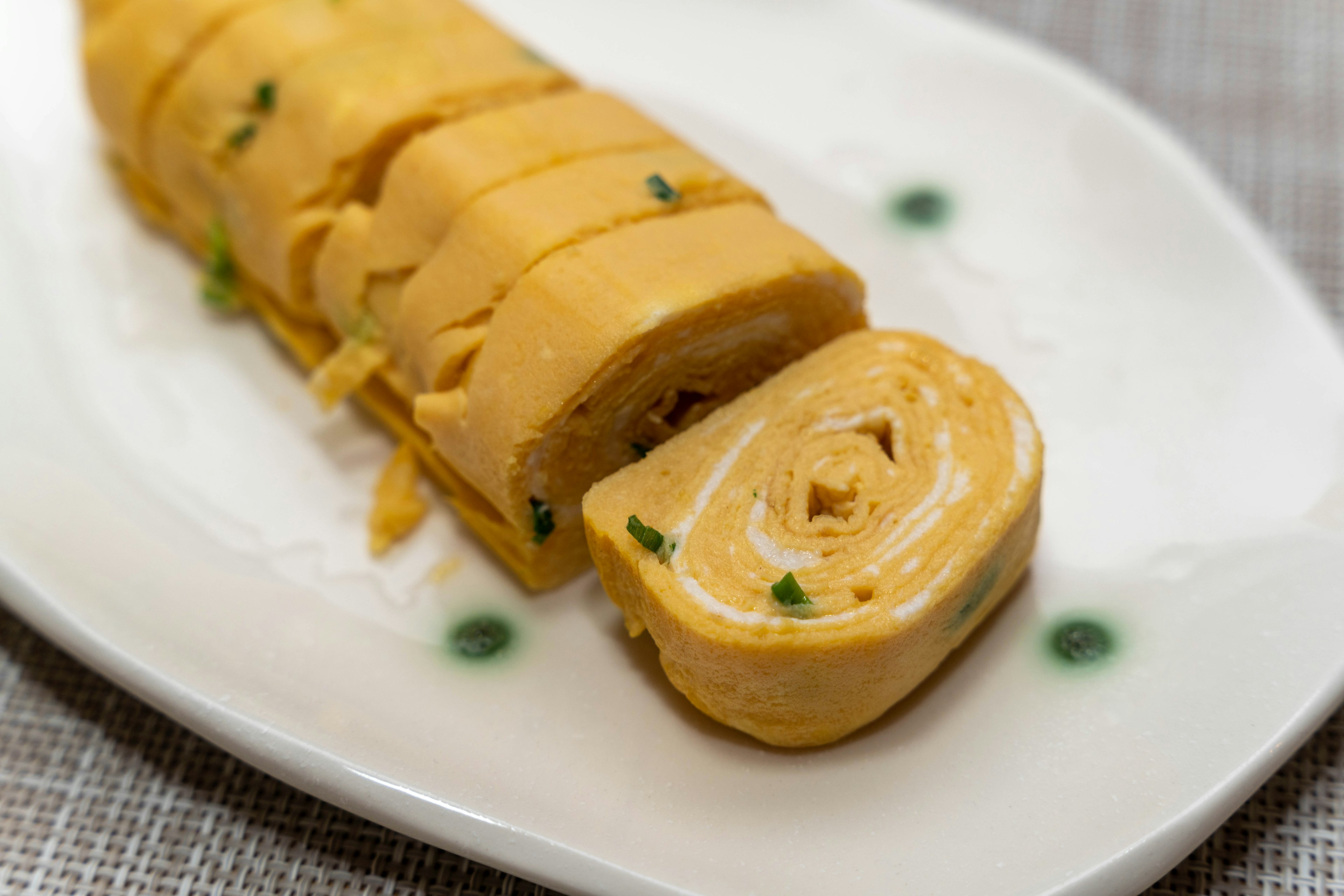 Omelette roulée tranchée présentée sur une assiette blanche