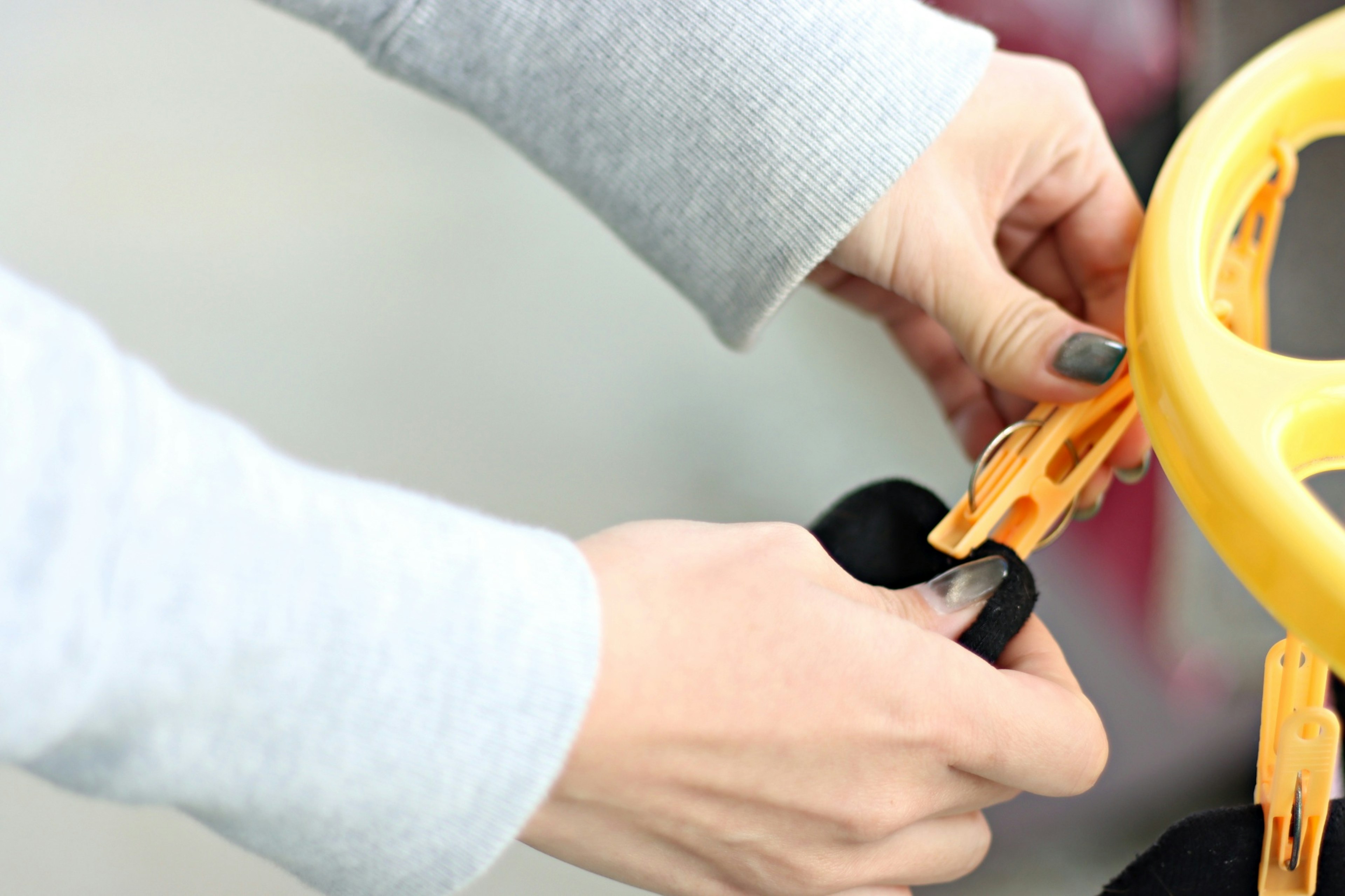 Hands adjusting a yellow steering wheel of a toy