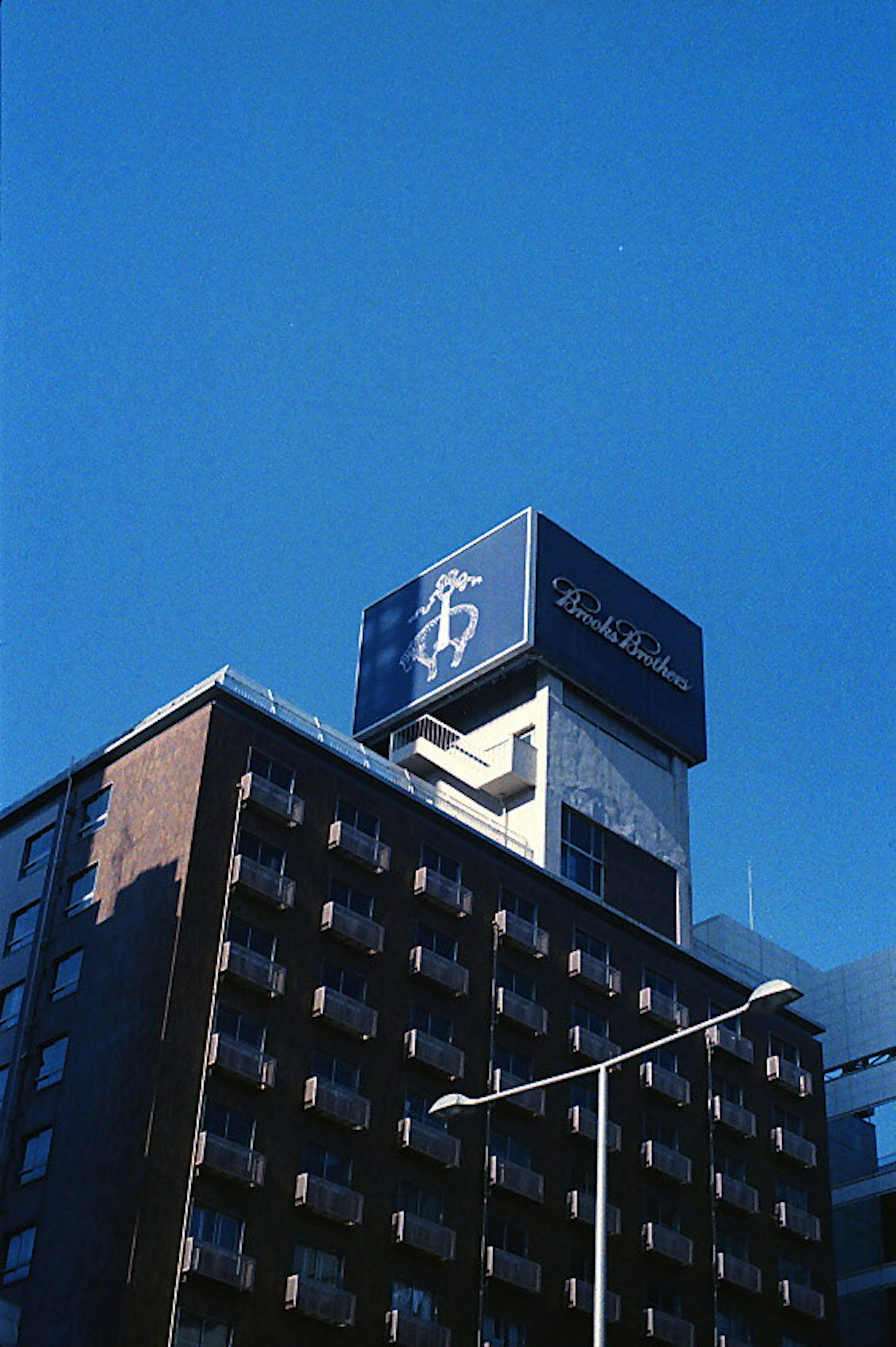 High-rise building with a sign under a clear blue sky