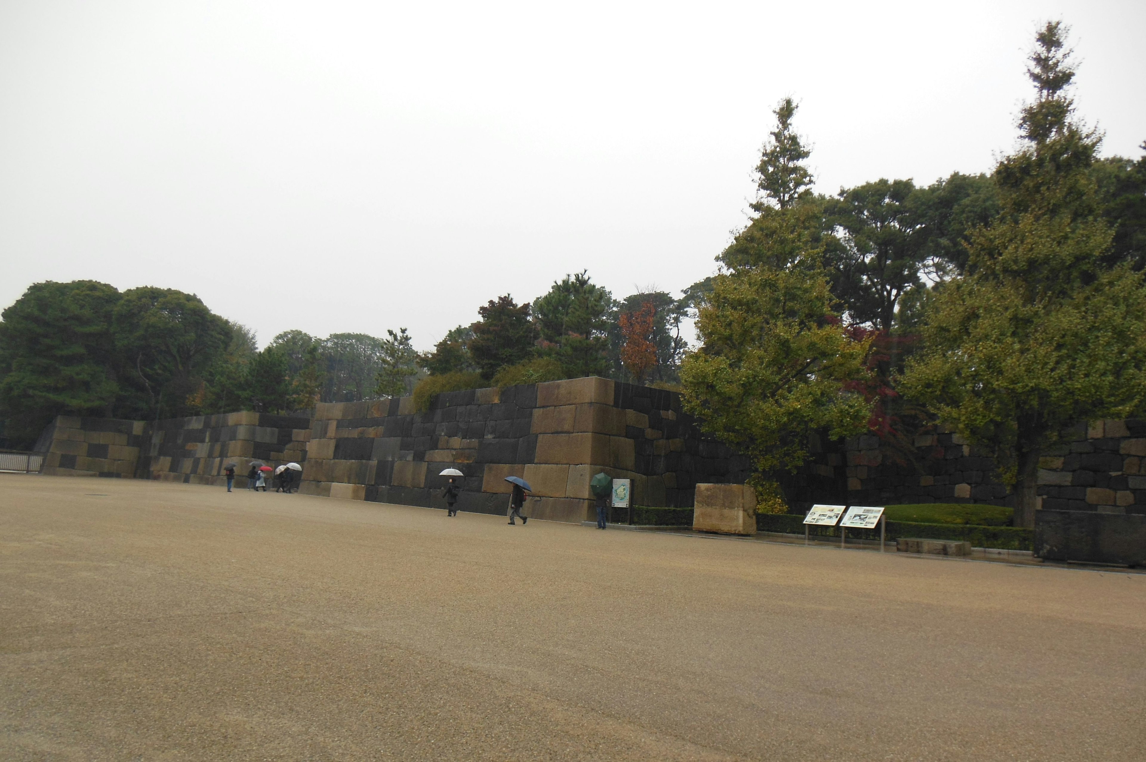 潮濕天氣下的公園景觀，古老的石牆和綠色樹木