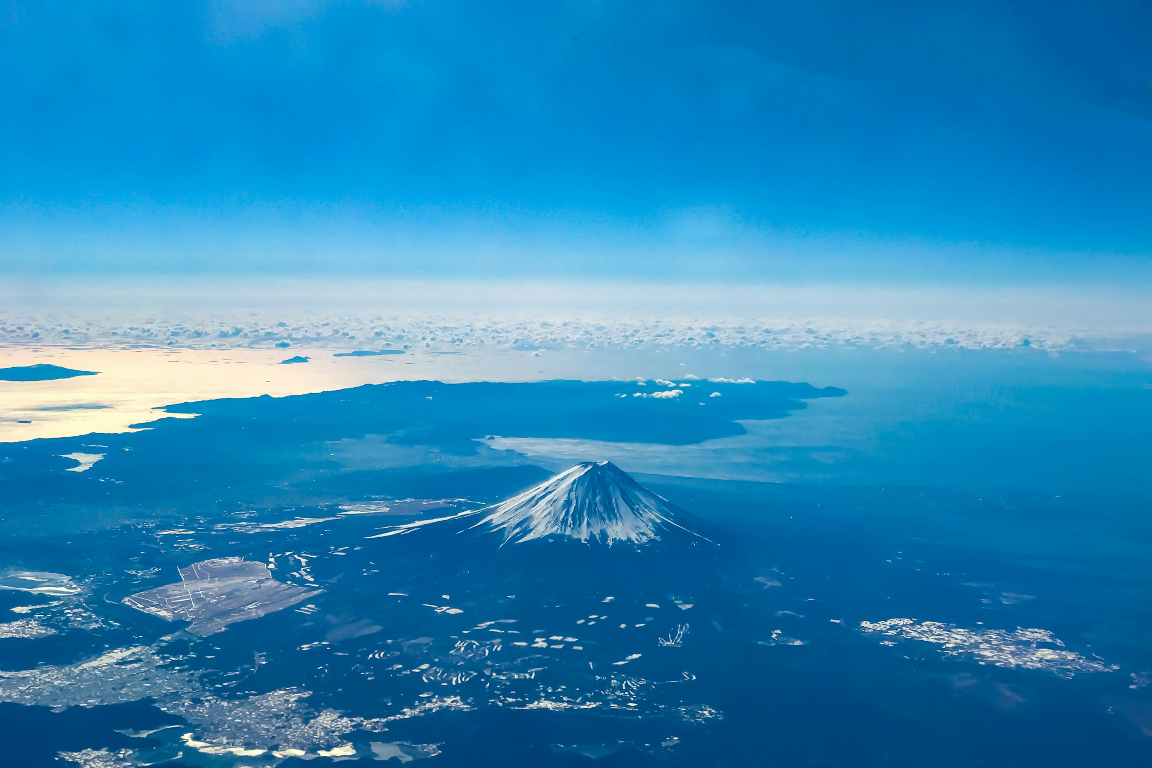 Luftaufnahme des Berges Fuji mit einem schönen blauen Himmel und Wolken, die nahegelegene Inseln umgeben