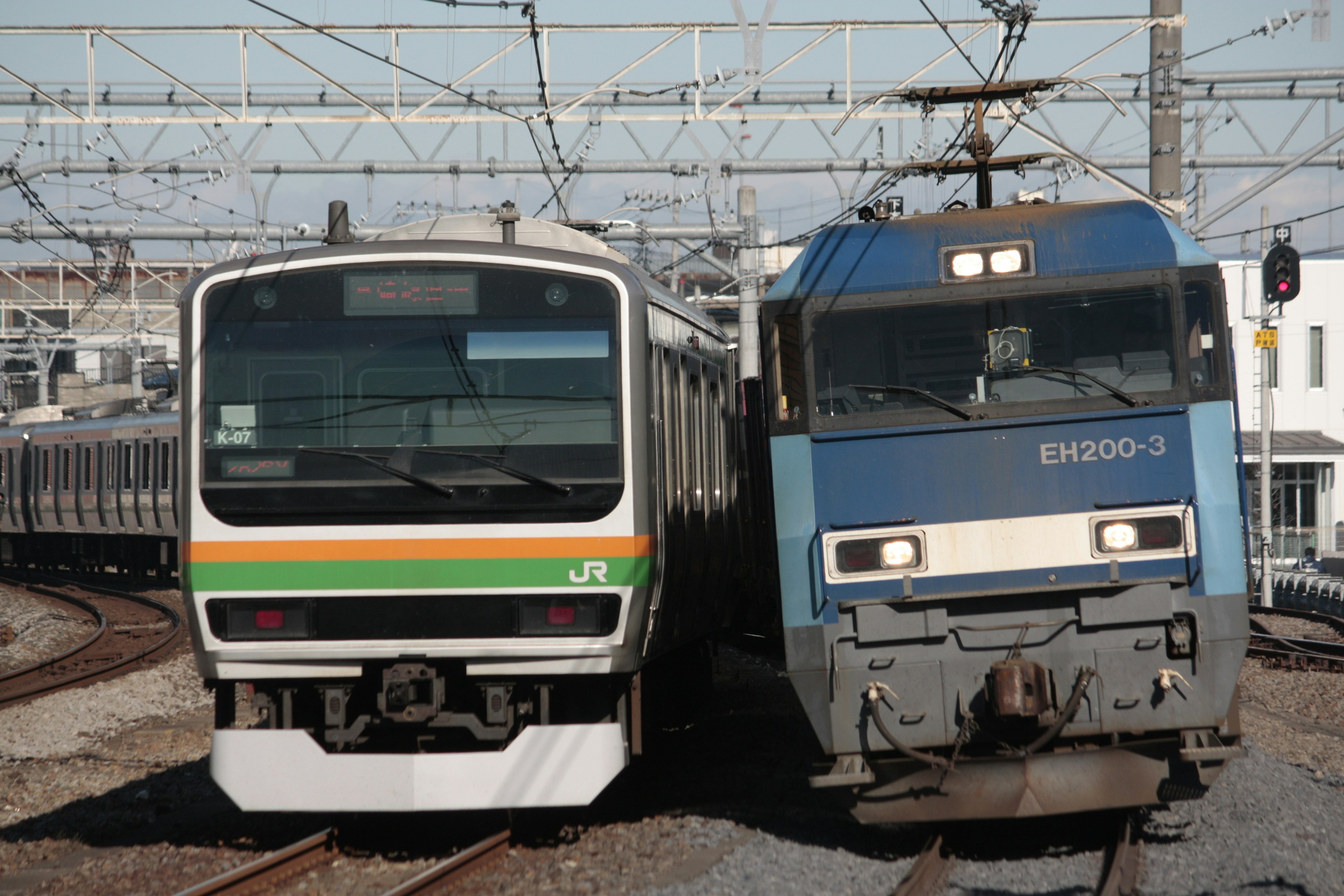 Dos trenes acercándose en las vías con un tren eléctrico y una locomotora