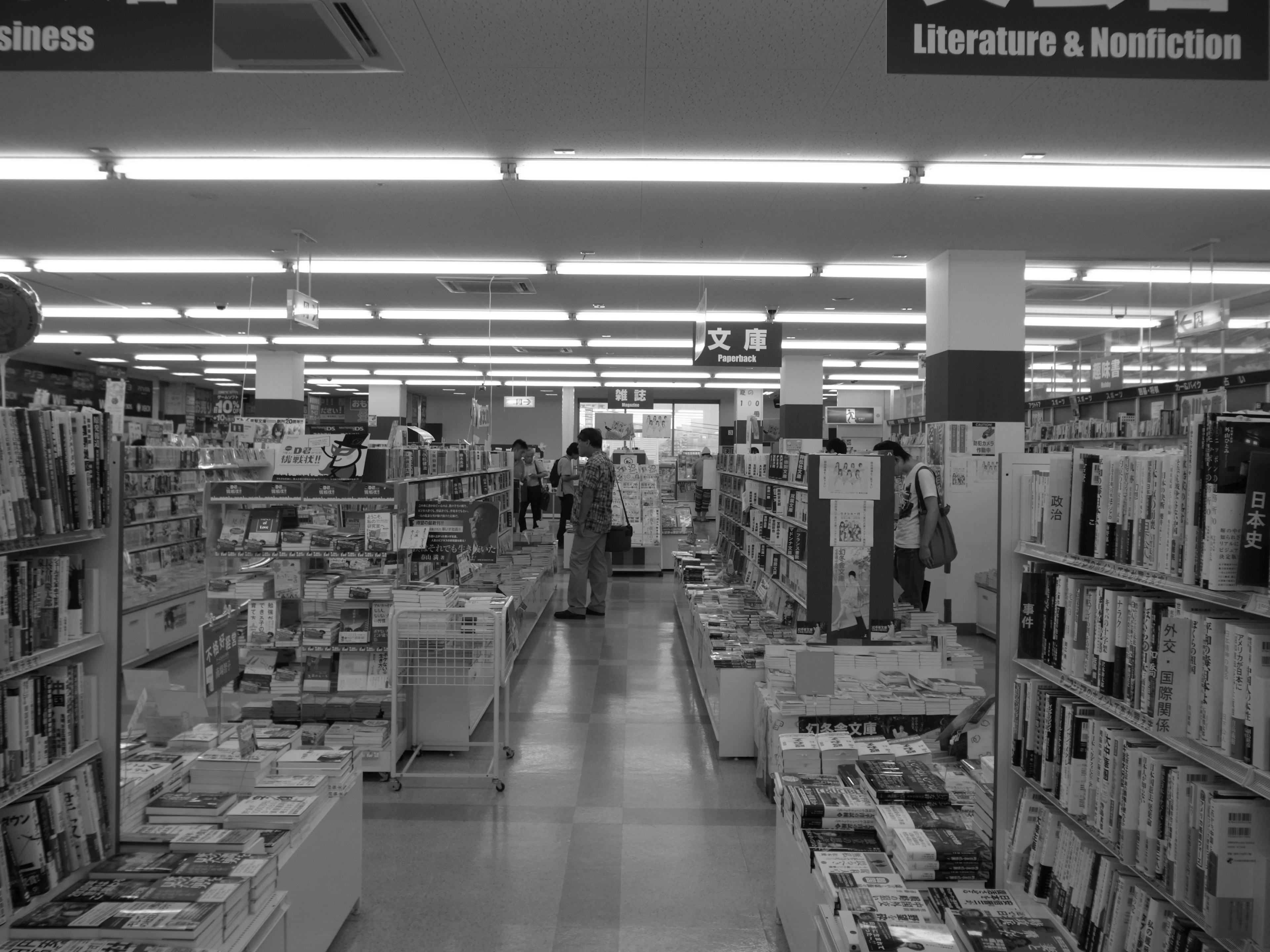 Interior of a bookstore with shelves filled with books and customers browsing