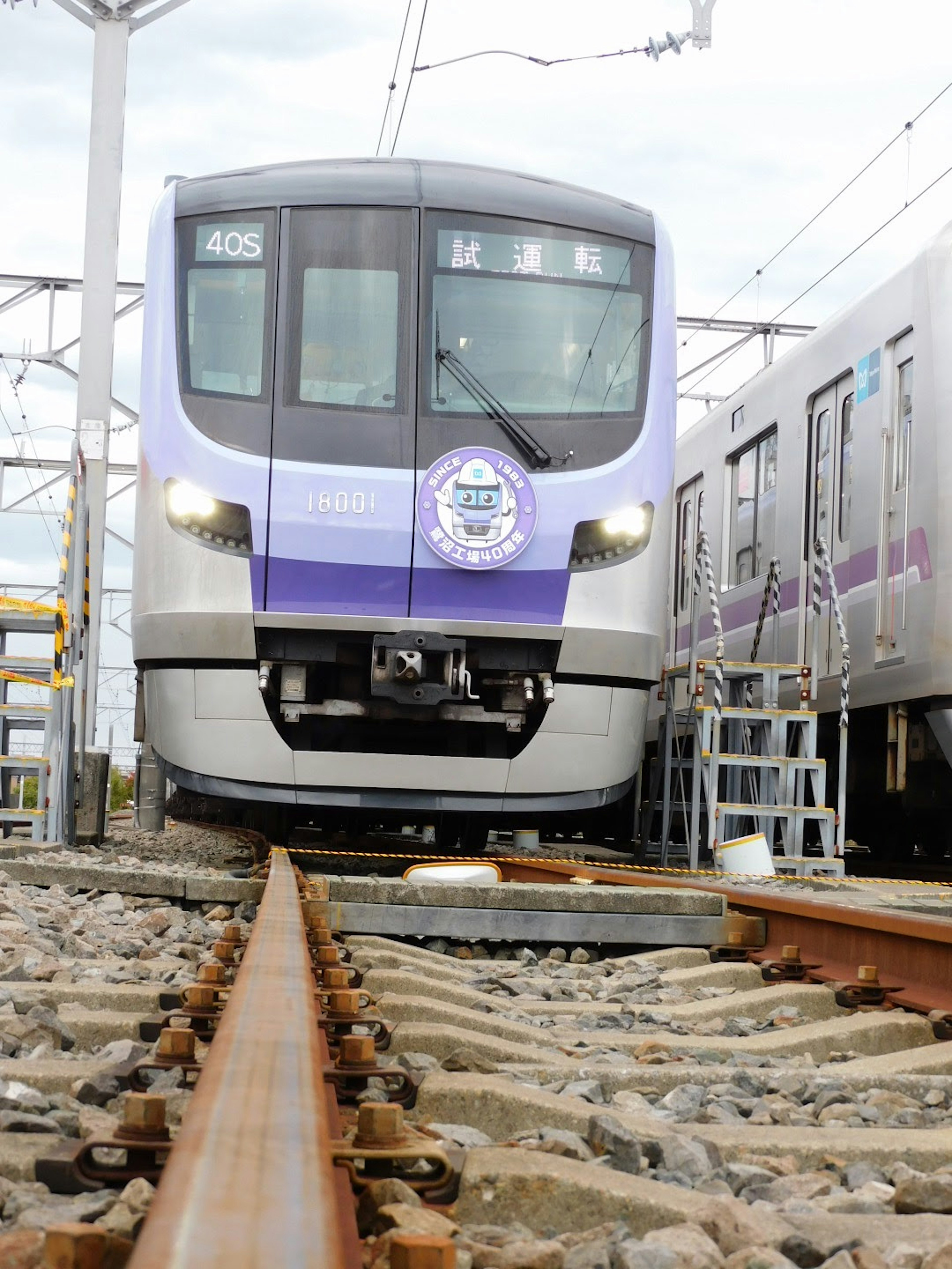 Sebuah kereta bertema ungu berhenti di rel