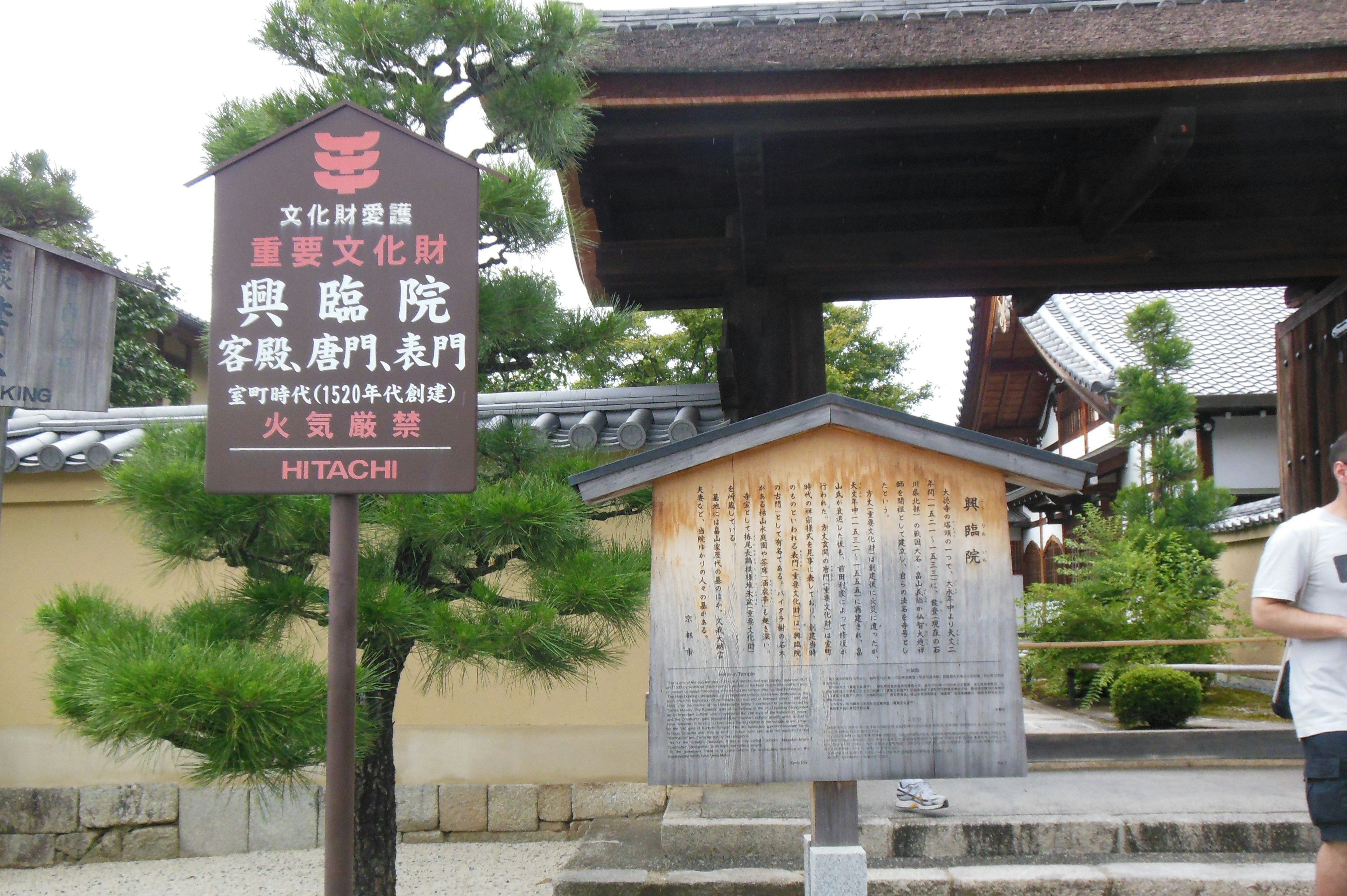 Eingang eines traditionellen japanischen Tempels mit einem Schild und einer Holztafel