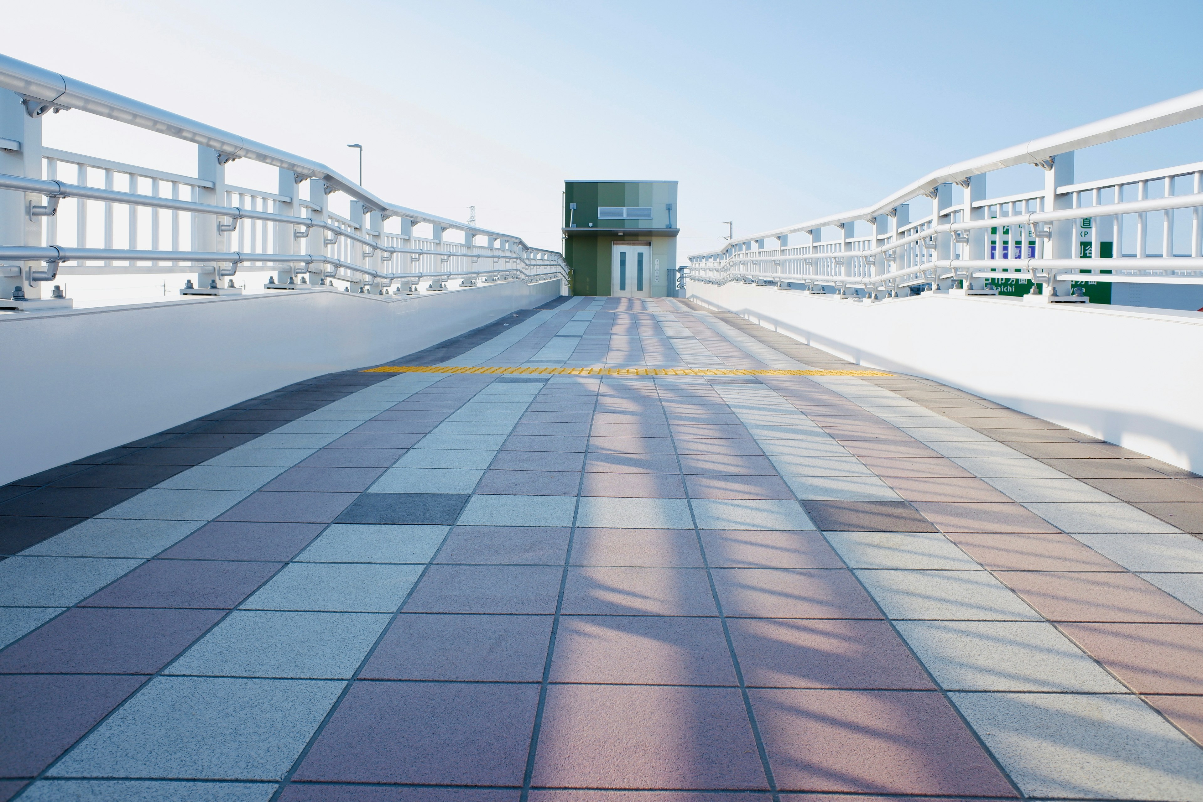 Modern walkway with colorful tile patterns under a bright blue sky