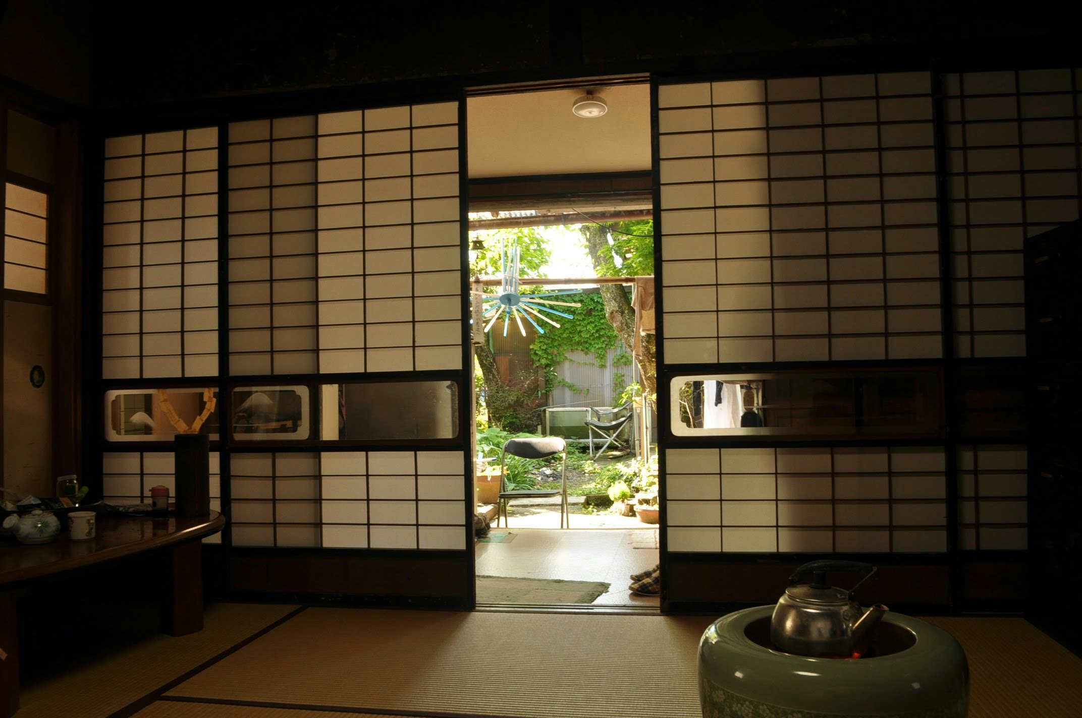 Interno di una stanza giapponese tradizionale con porte scorrevoli e giardino visibile
