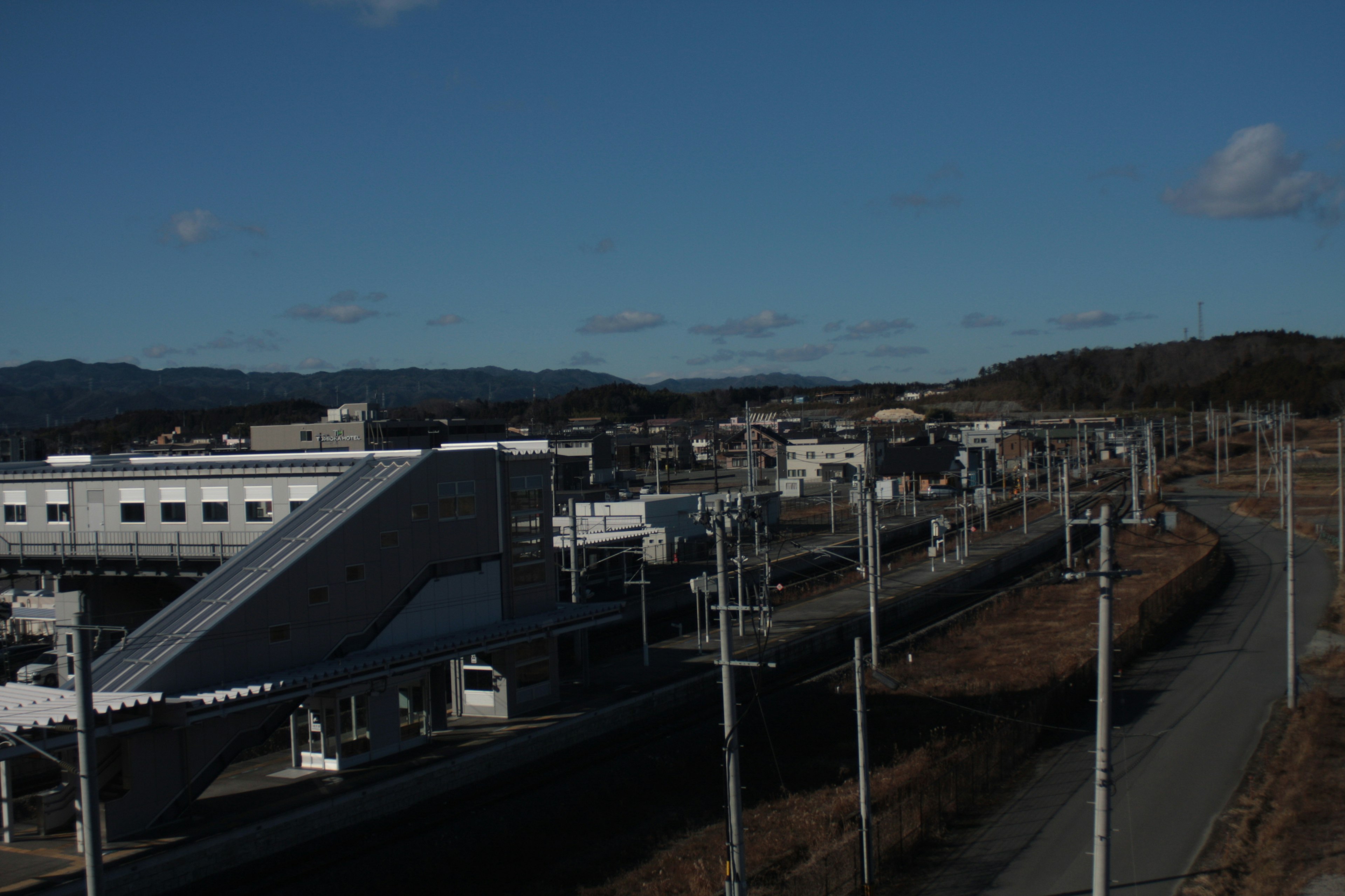 Paysage industriel avec des bâtiments et des montagnes sous un ciel bleu