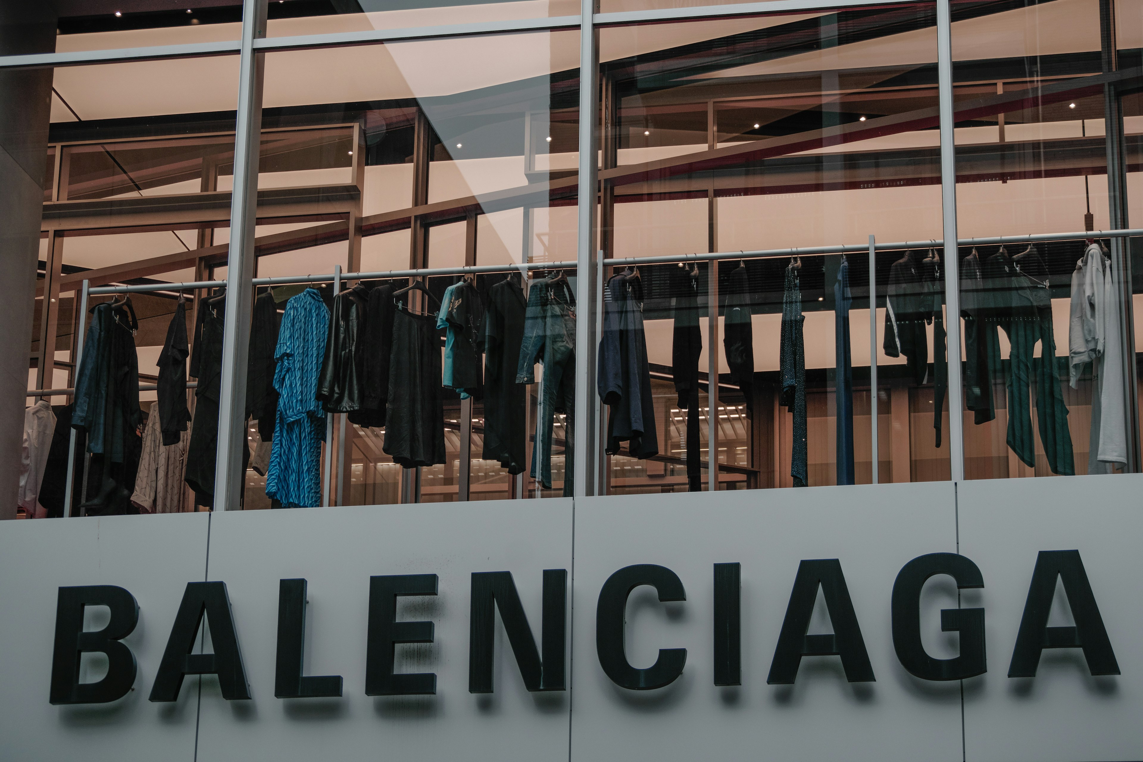 Exhibición de varias prendas colgadas afuera de una tienda Balenciaga