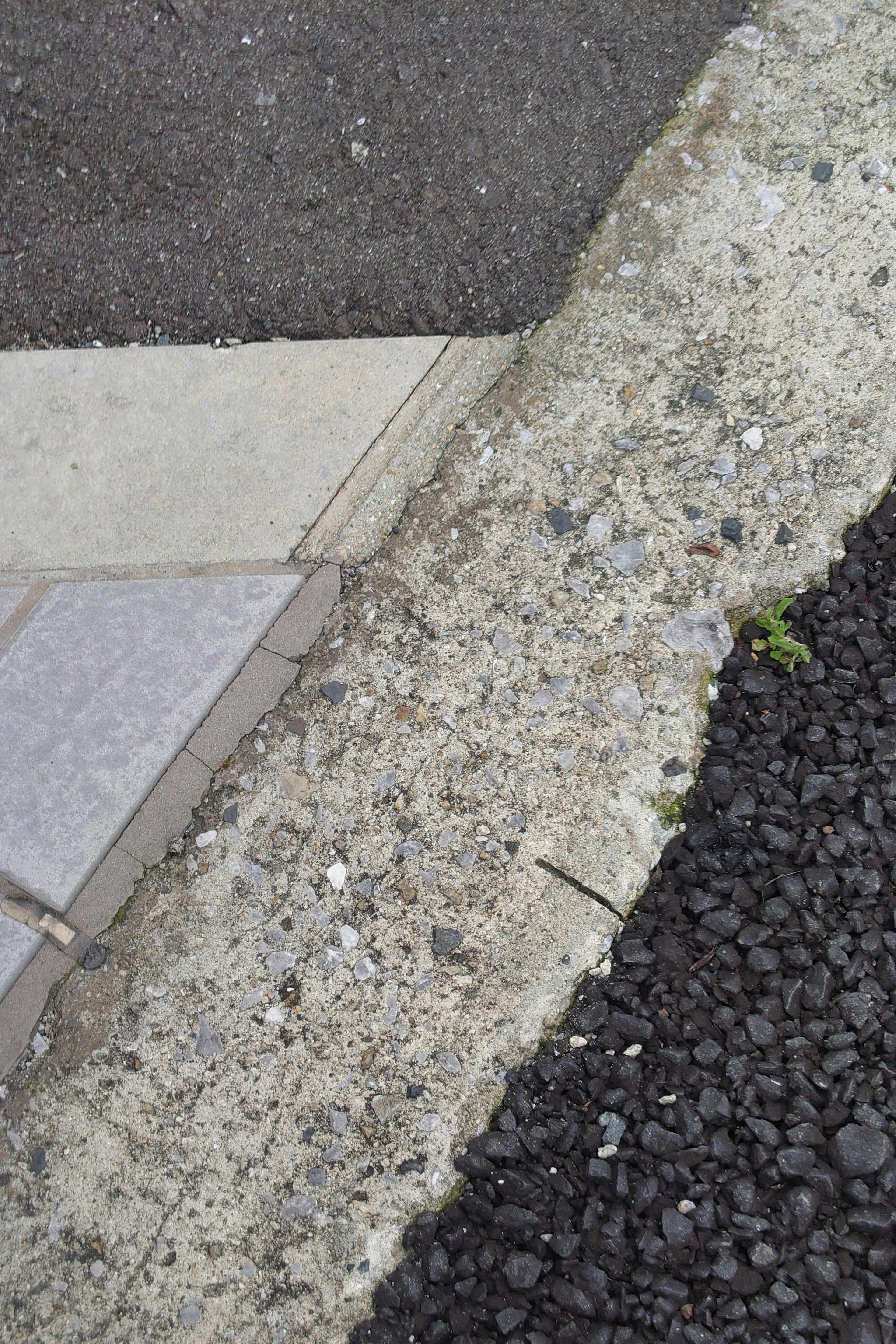 Esquina de una carretera que muestra diferentes materiales y texturas