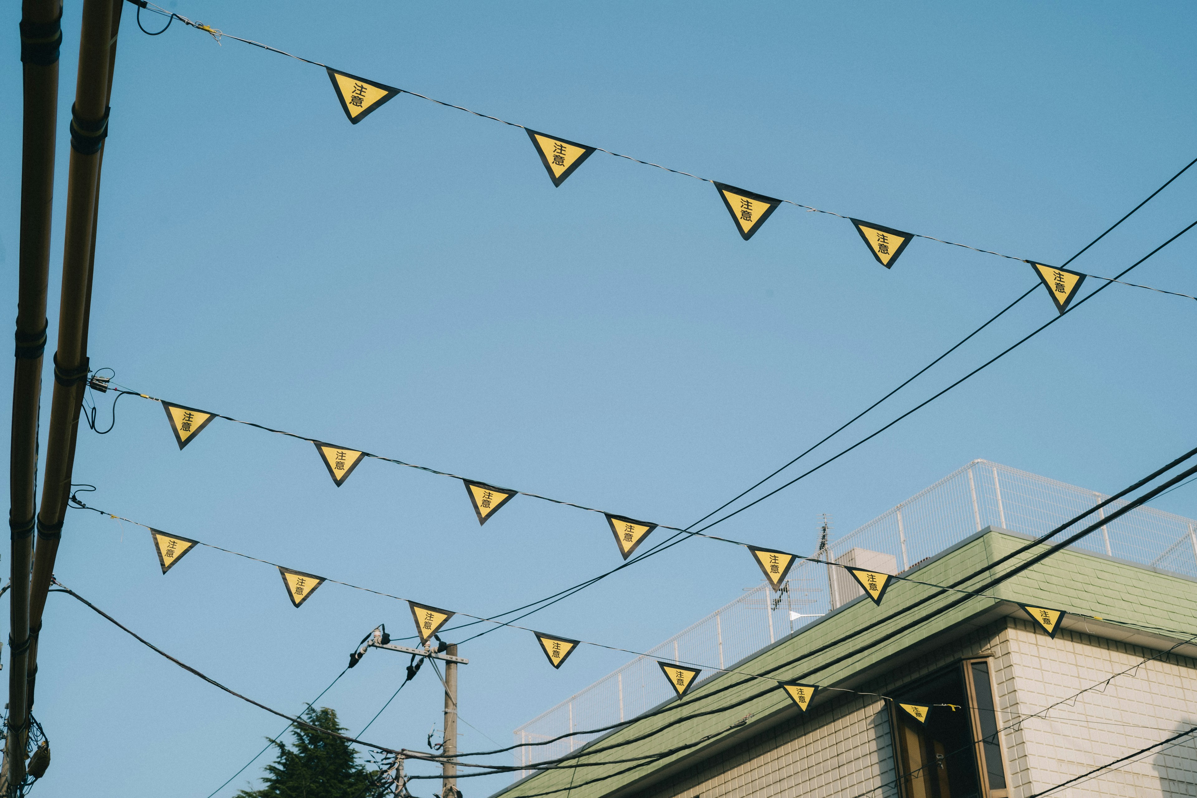 Street view with yellow triangular flags hanging under a blue sky