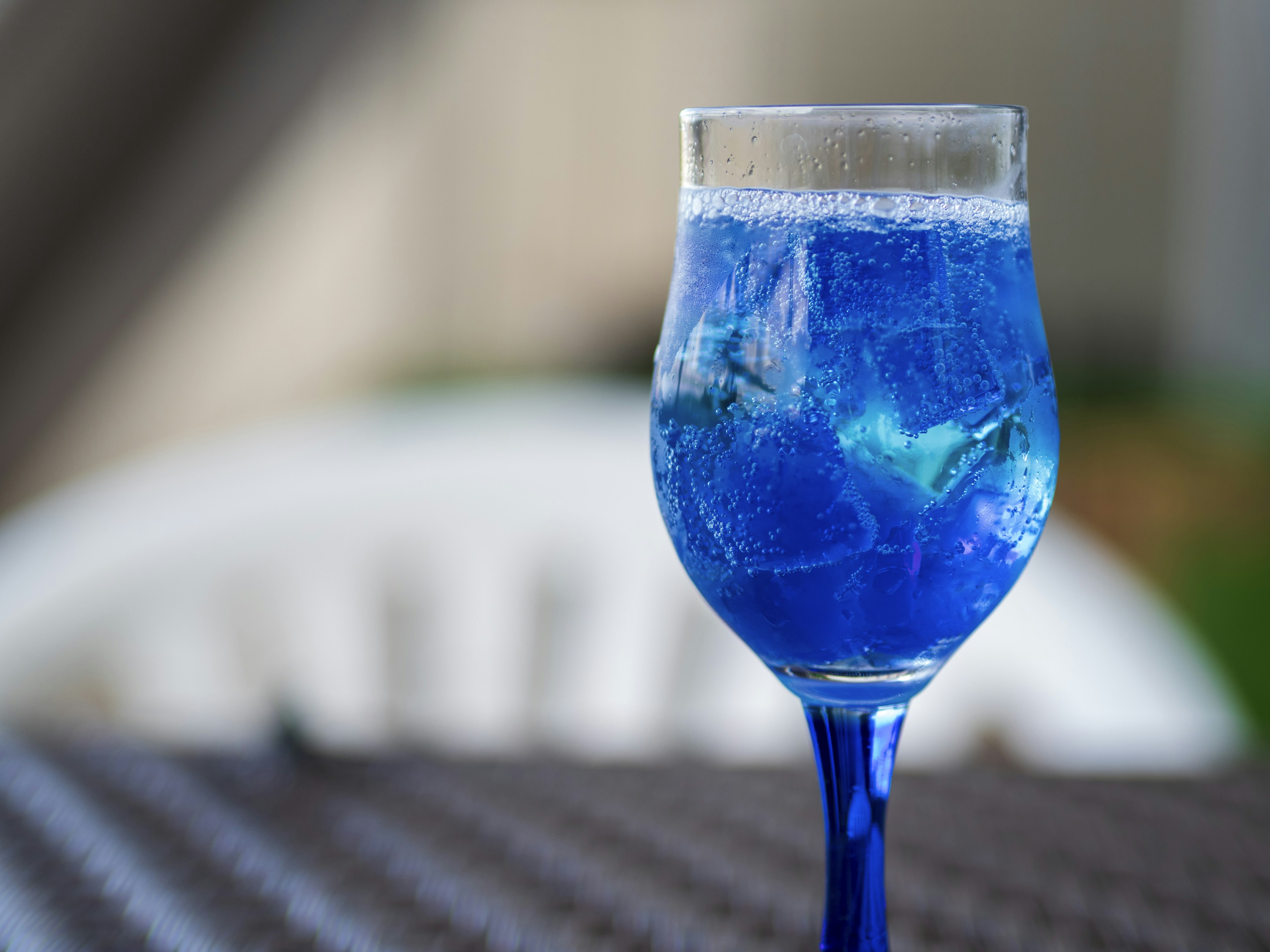 Un vaso de bebida azul con burbujas sobre una mesa