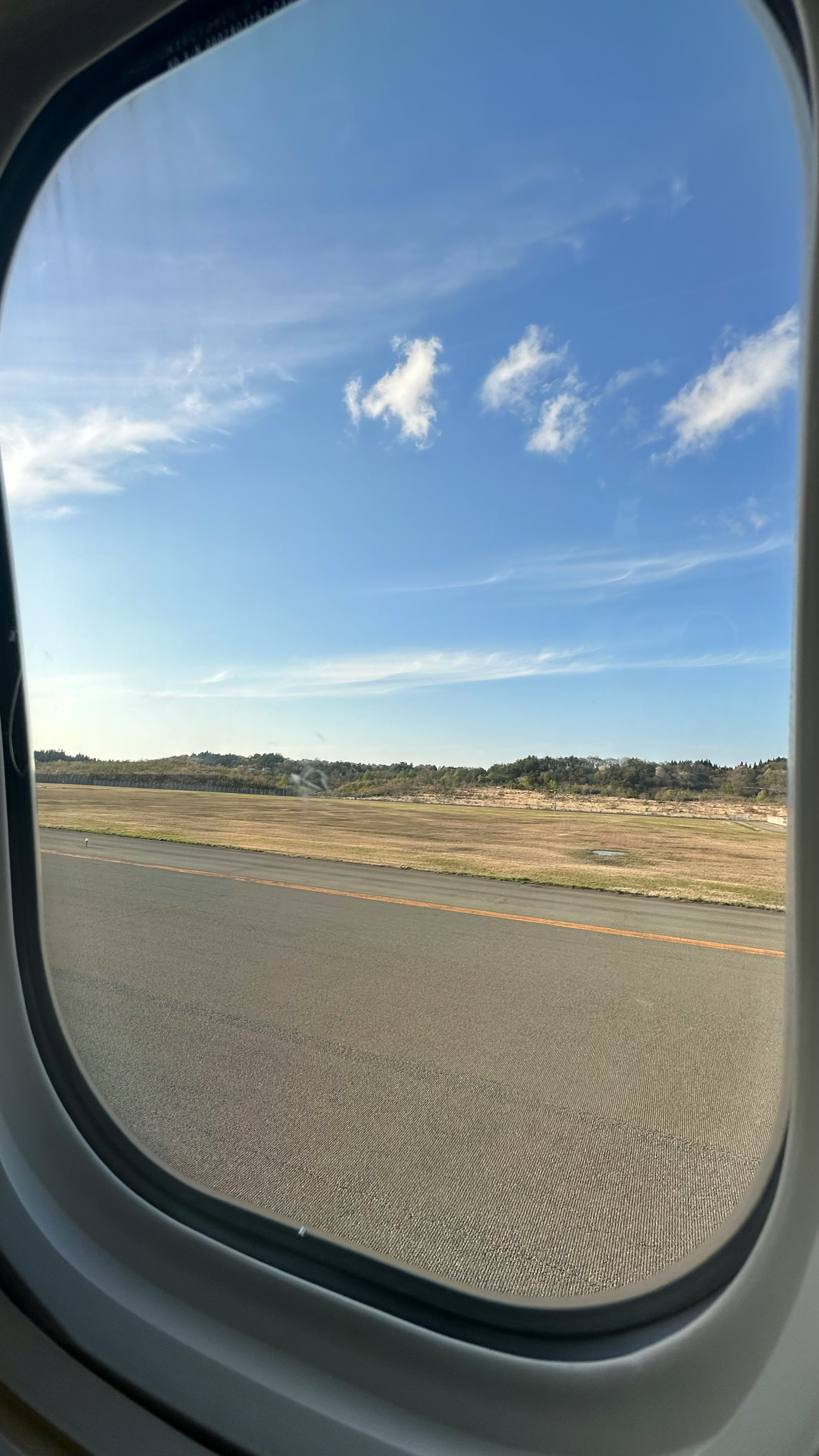 View of blue sky and clouds through an airplane window