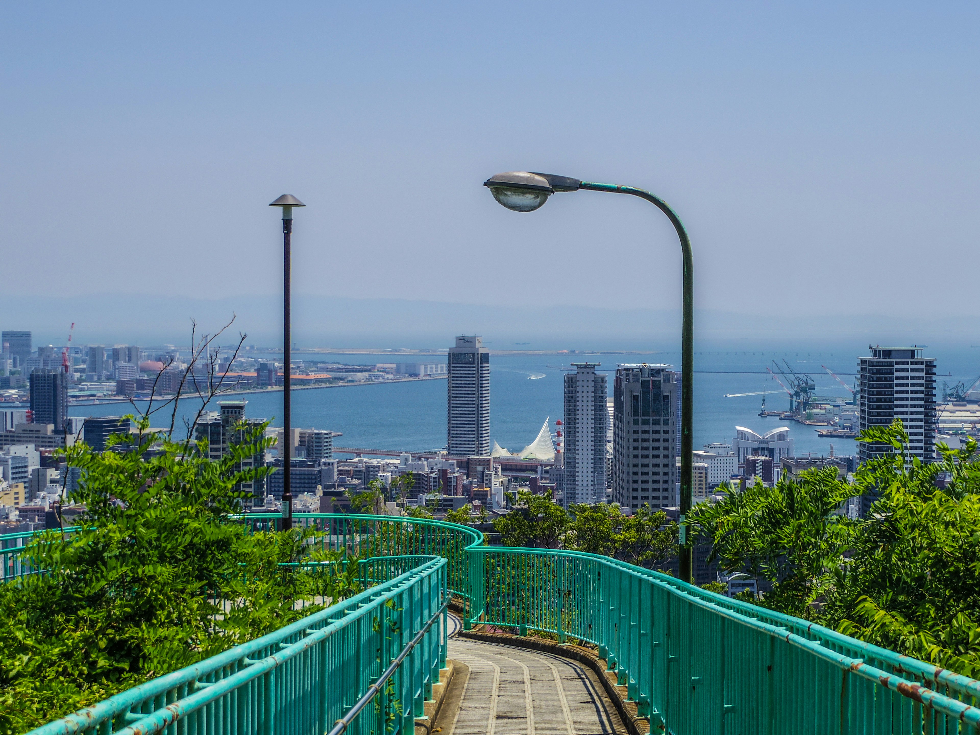 Scenic city view with a beautiful ocean backdrop green pathway leading down