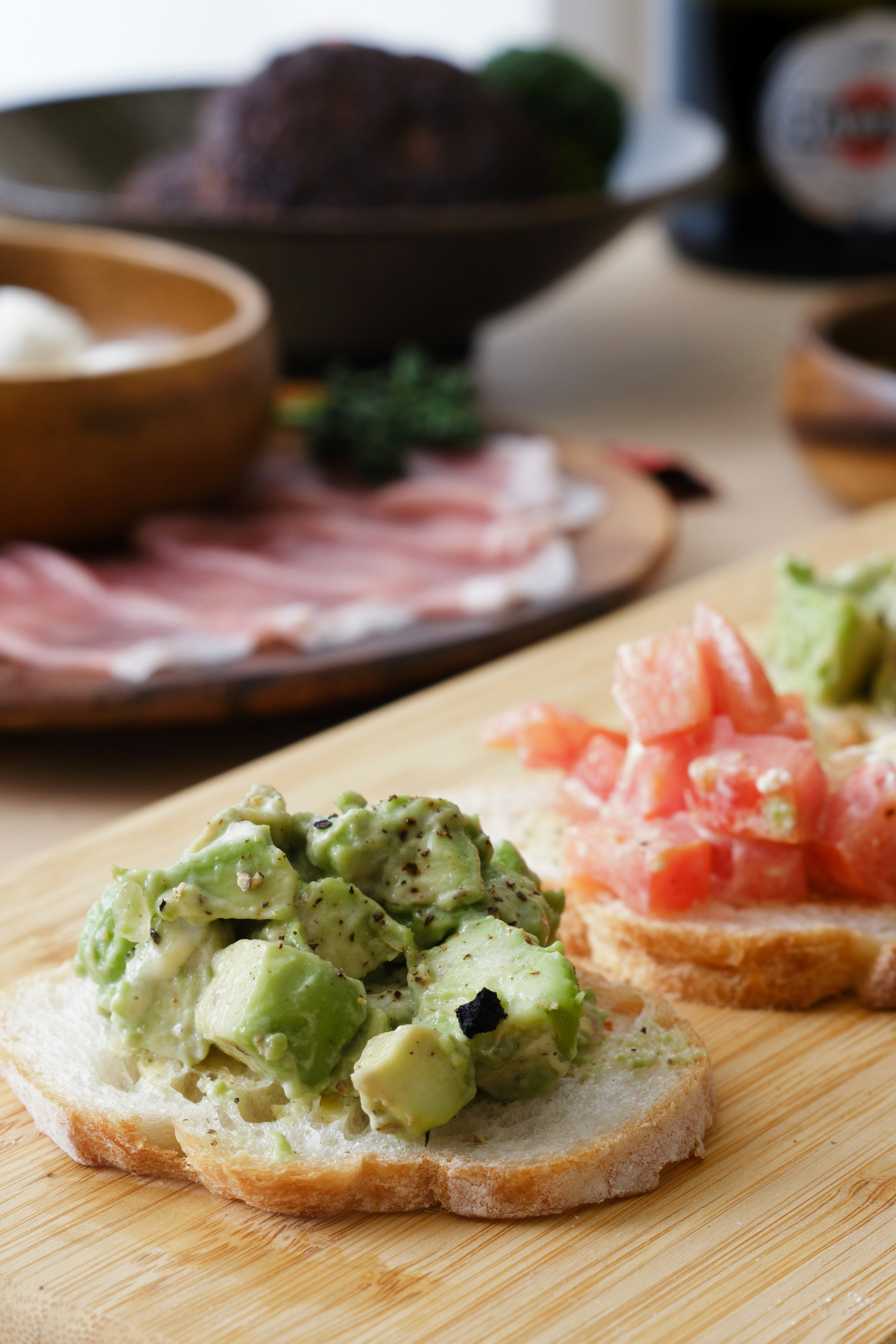 Avocado and tomato toast served on a wooden board